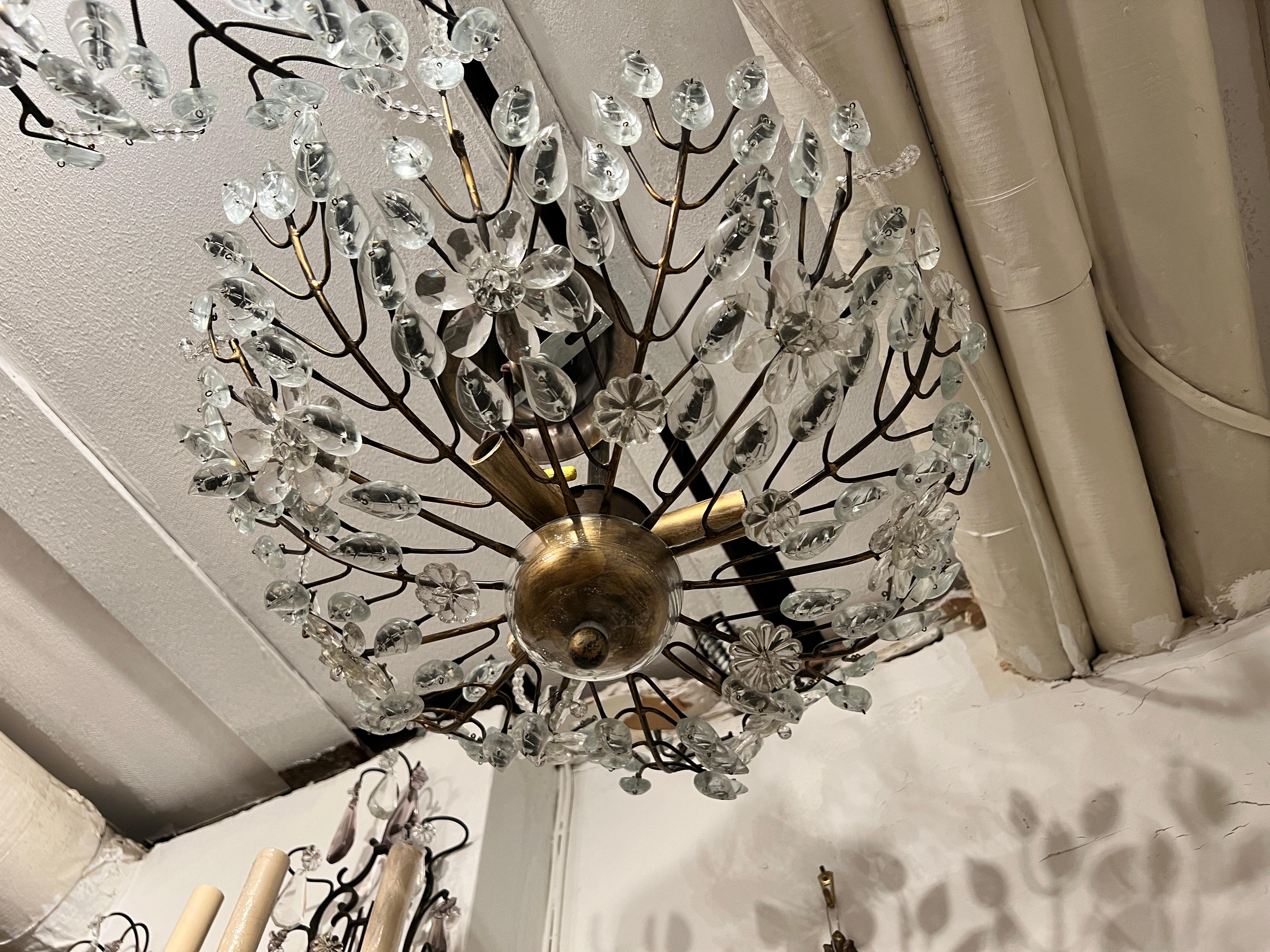 A pair of circa 1940's French patinated bronze light fixtures with molded glass leaves and crystal flowers with three interior lights. Sold individually.

Measurements:
Current drop: 14.5