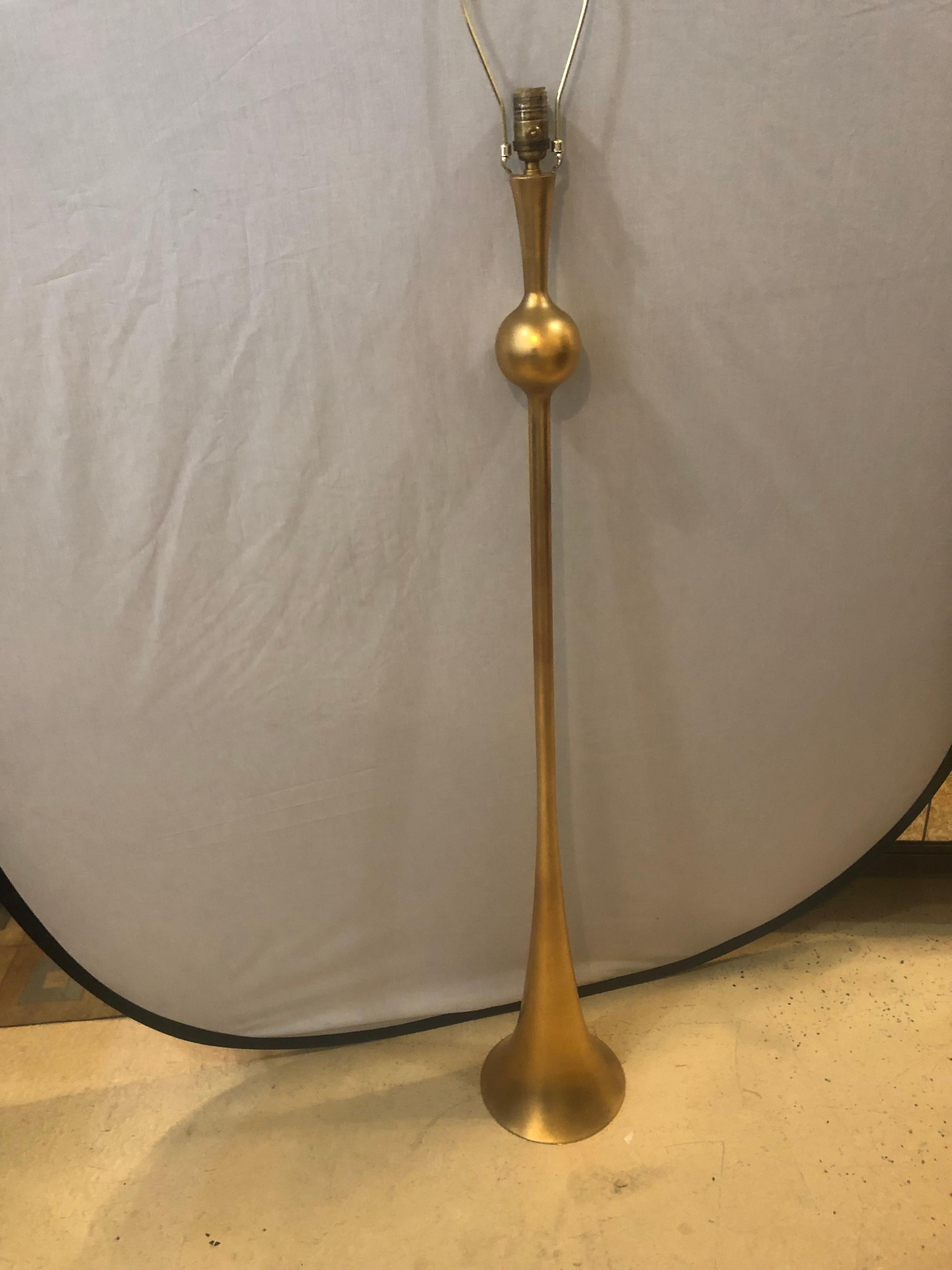Gilt metal Hollywood Regency style trumpet standing lamp having sleek and stylish lines and a custom lamp shade this single bulb standing or tall lamp is a must have for that corner that needs not only light but conversation.