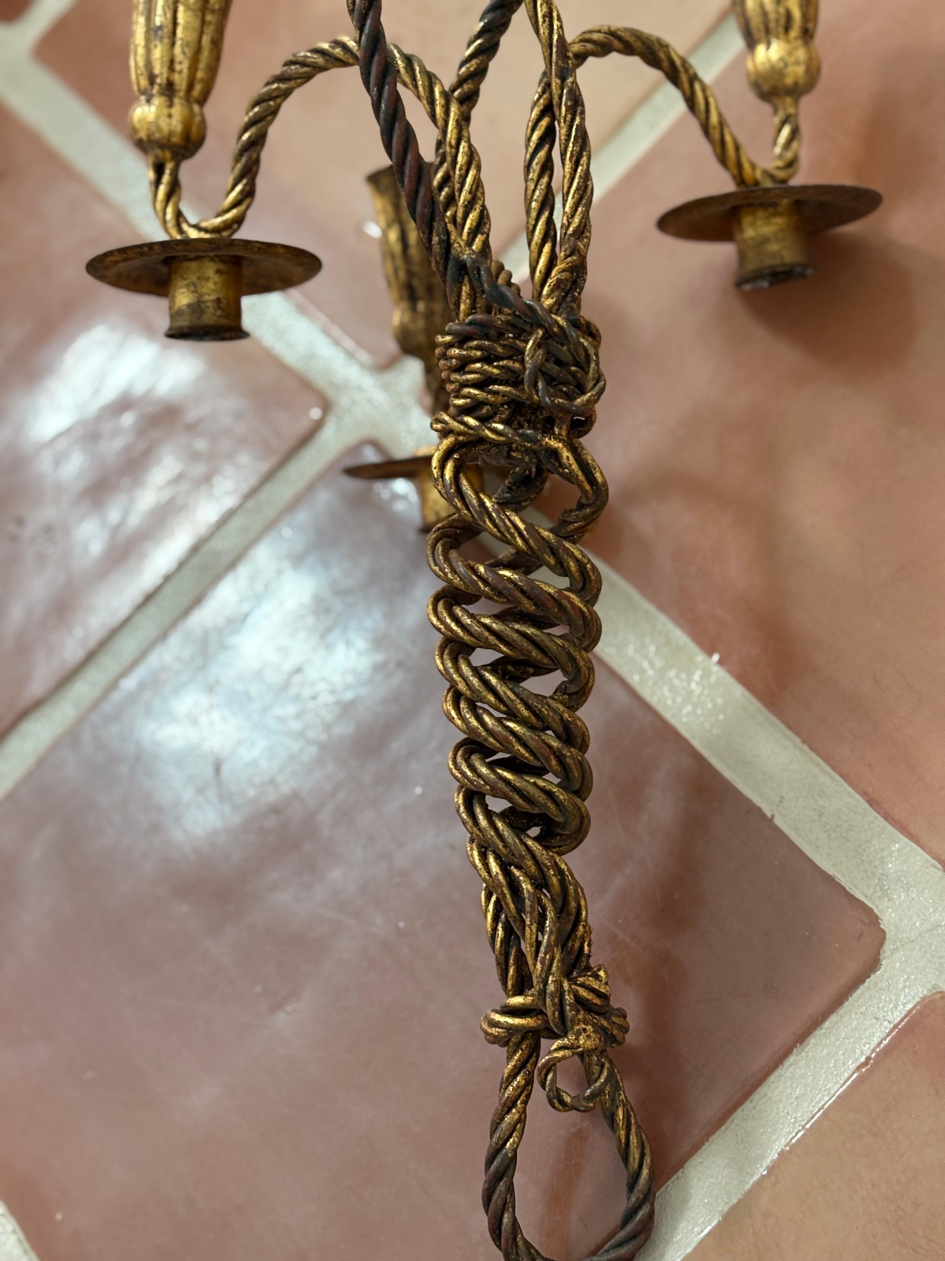 Il s'agit d'une paire d'appliques italiennes vintage en métal doré avec corde et glands en très bon état. 
Elles datent des années 1950 et sont assorties de bancs et de jardinières. 