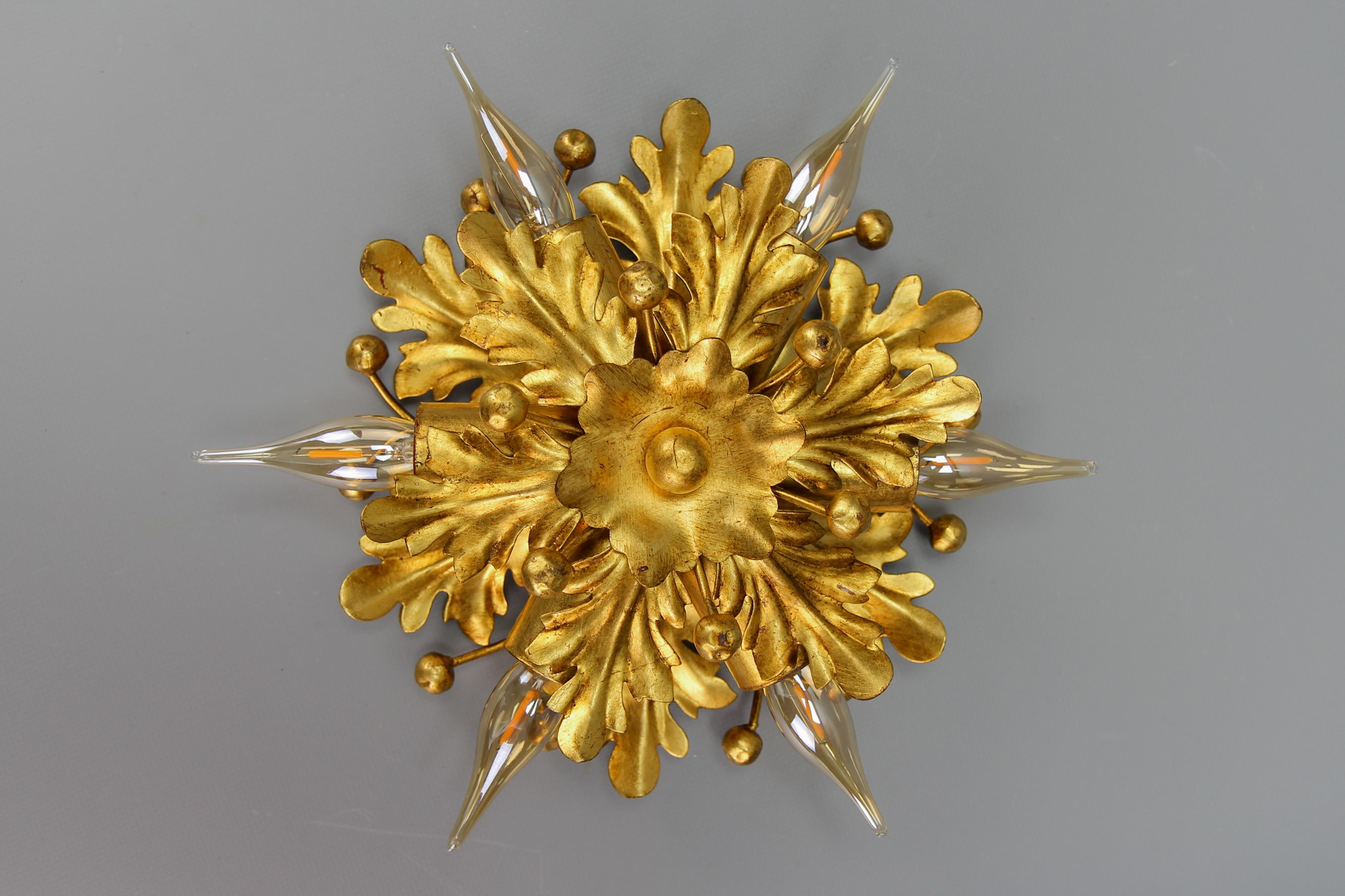Hollywood Regency style gilt metal sunburst-shaped leaf motif flush mount or sconce by Hans Möller, circa the 1970s.
A beautiful Hollywood Regency-style gilt metal sunburst-shaped six-light wall lamp, adorned with elegantly shaped leaves and small