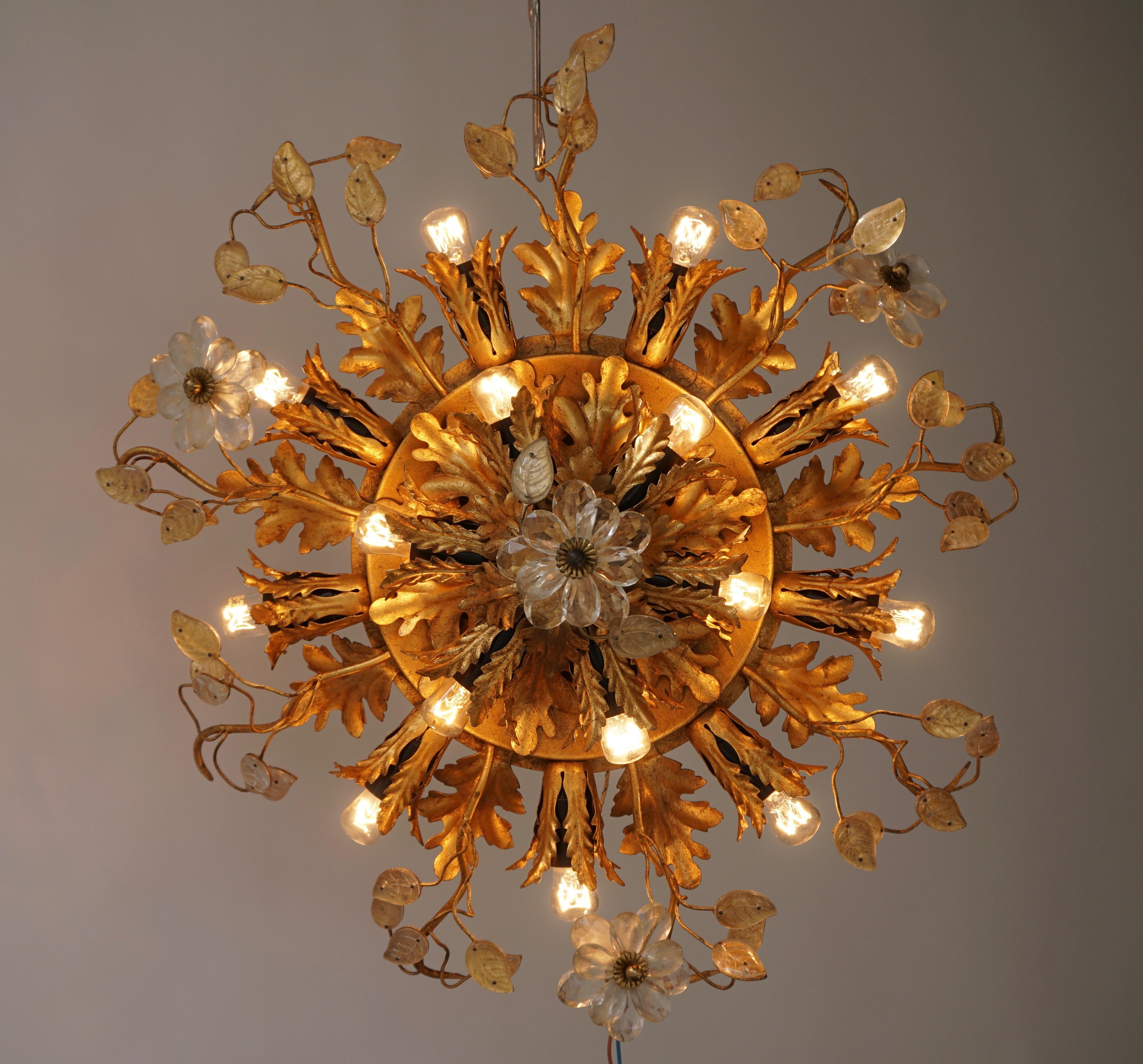 Gilt metal sunburst flush mount or sconce with glass flowers, Italy. 
Materials: Gold “antique” painted metal (iron) presenting European oak leaves (quercus robur) and ferns. Bakelite sockets. 
Measures: 
Diameter 55 cm, depth 20 cm. Fifteen E14