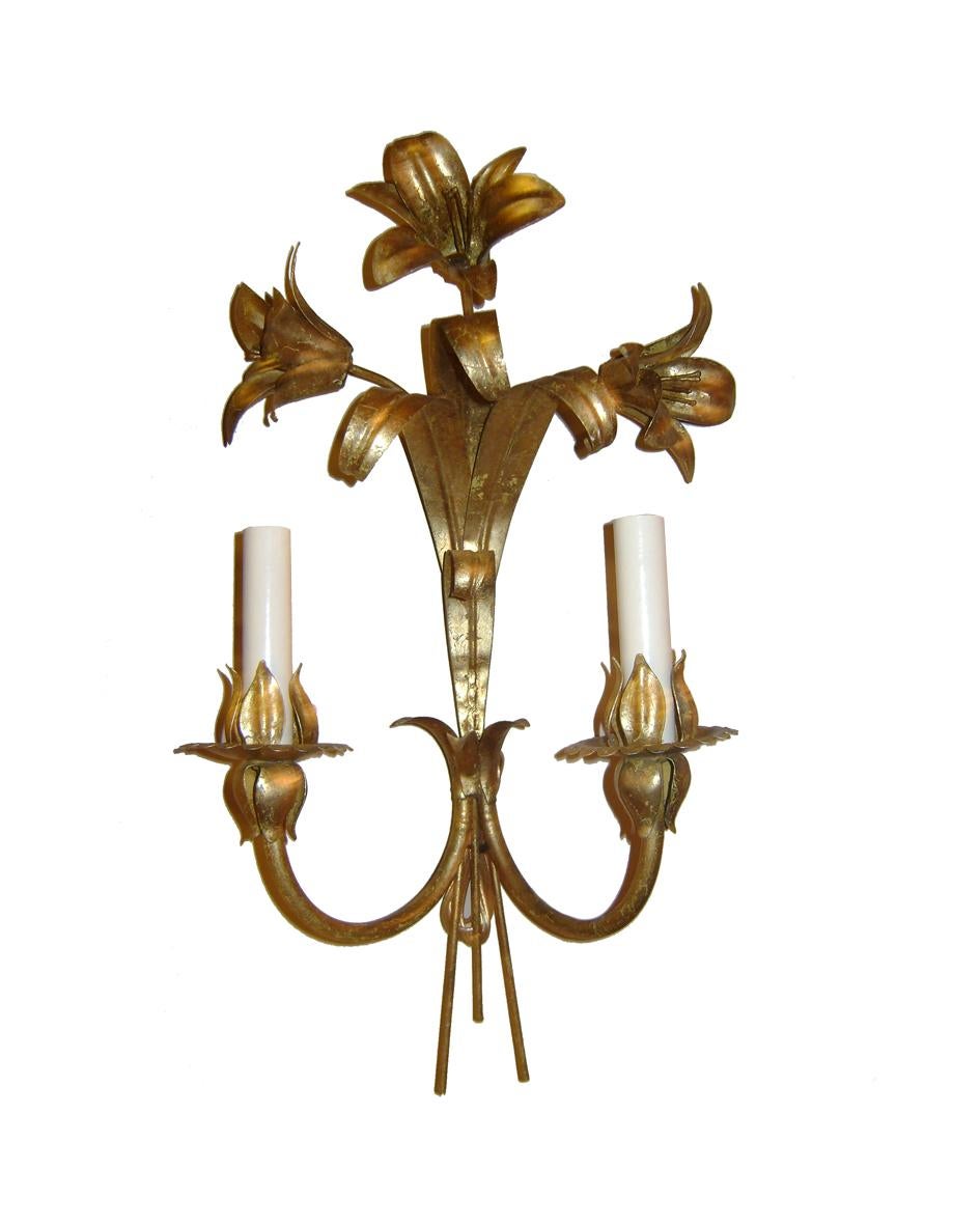 Pair of 1940s Italian gilt metal sconces with two-arm and lilies motif.

Measurements:
Height 19