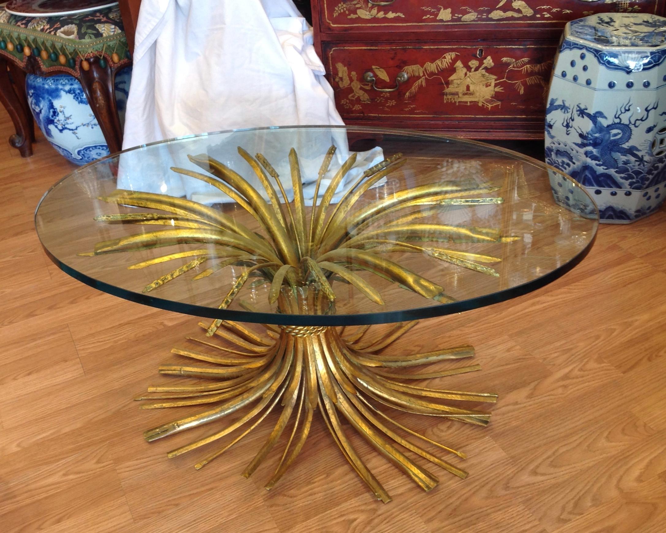 Inspired by the classic table in the salon of CoCo Chanel. Superior quality and workmanship
with a soft gold finish of varied shafts of wheat. It is mounted with a thick glass top.