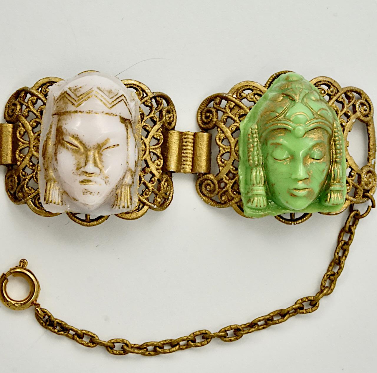 Gilt metal ornate coloured glass faces bracelet, with a safety chain. The bracelet measures length 20.5 cm / 8 inches by width 2.4 cm / .9 inch, it is light to wear. There is wear to the gilt. 

This is an unusual and beautiful coloured faces