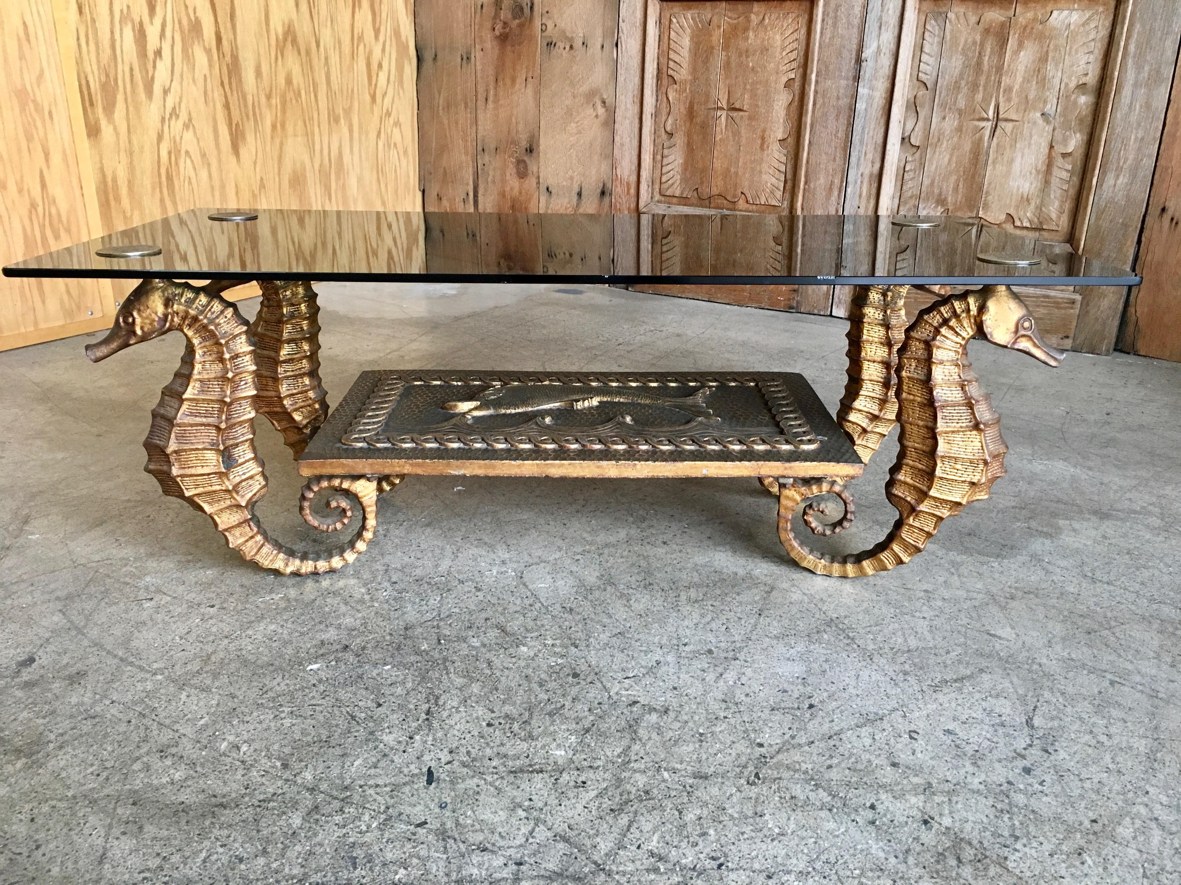 Modernist gilt metal seahorse coffee table with smoked glass and dolphin center panel.