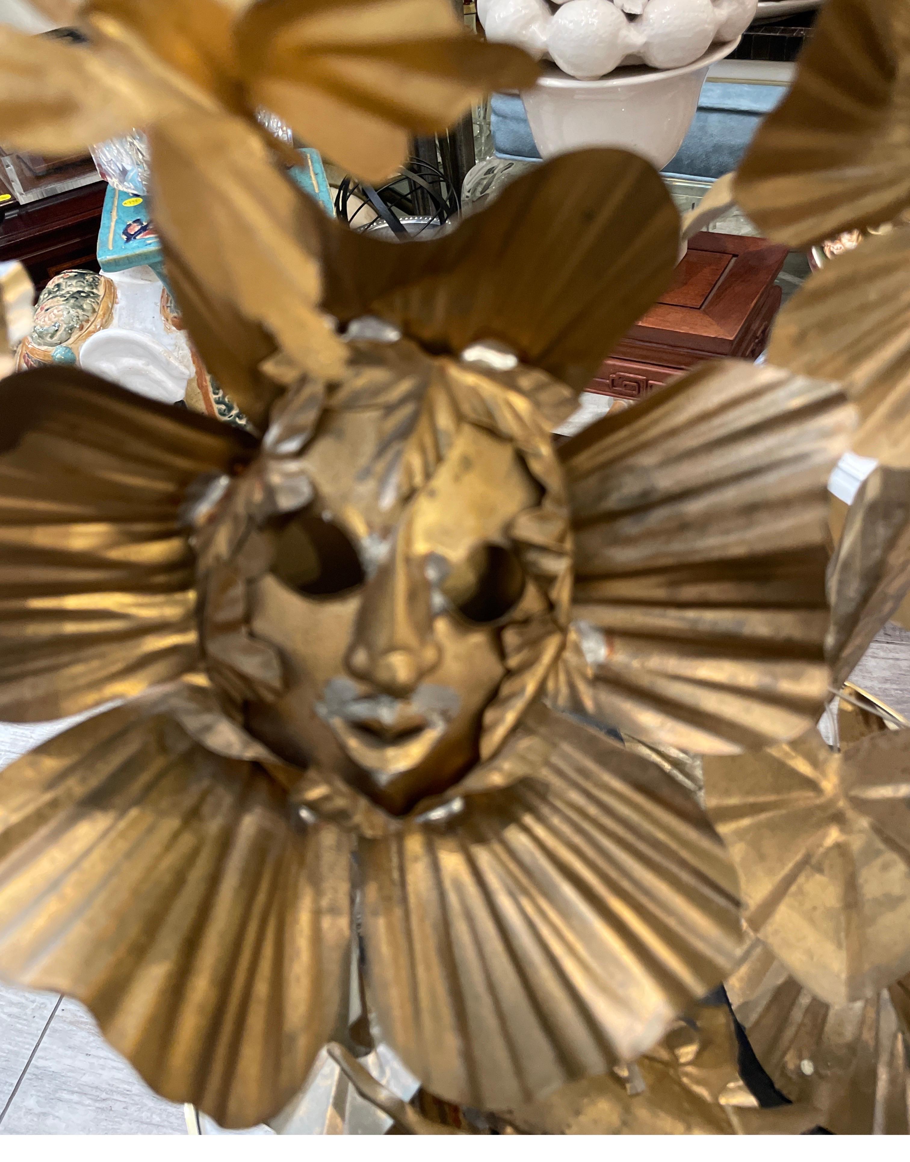 Wonderful and unique gilt metal sculpture mounted on black painted wood base.  The sculpture depicts the sun, butterflies, crabs and multiple lilies.  