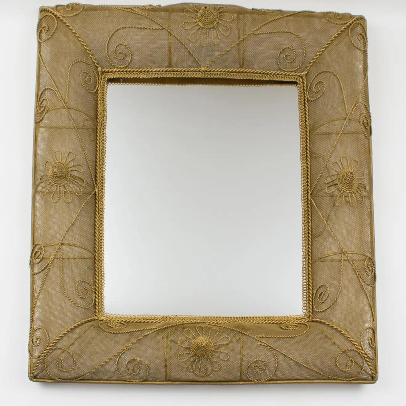 This elegant 1950s rectangular gilt metal wall-mounted mirror features interesting dimensional domed sides with raised detailing built with gilded metal mesh wire. The mirror can be placed in a landscape or portrait position thanks to two hooks at
