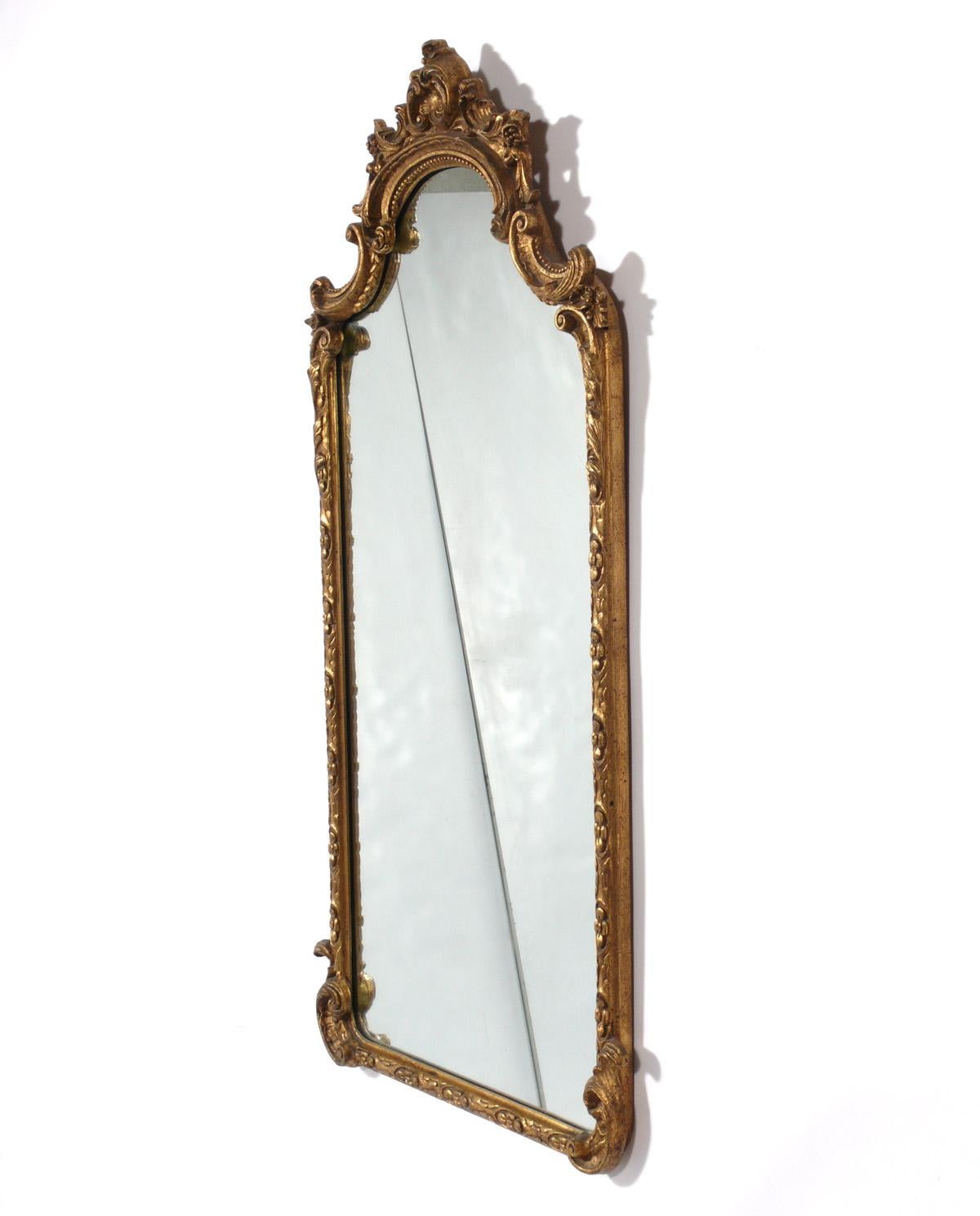 Gilt Mirror, probably Italian, circa 1940s. Retains wonderful original patina to the gilt wood frame and original mirrored glass. This rectangular shaped mirror is tall and thin, measuring height x width, making it a good candidate for a powder