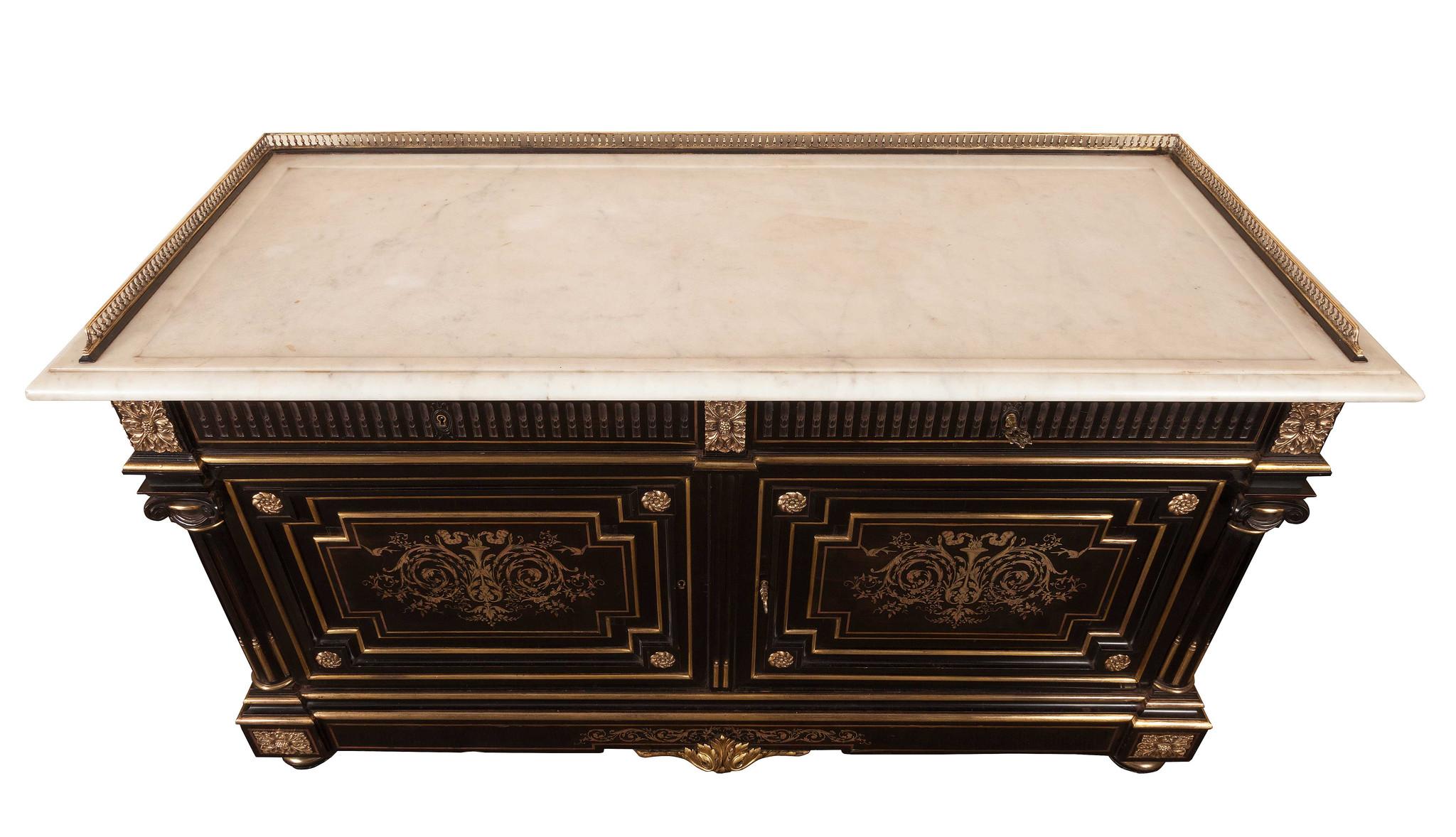 French Napoleon III ebony, gilt-mounted commode.
The hand-carved marble-top mounted with a brass gallery, two frieze drawers above brass inlaid panelled cupboards with gilt mounts. Quarter columns to both sides with scrolled capitals, with gilt