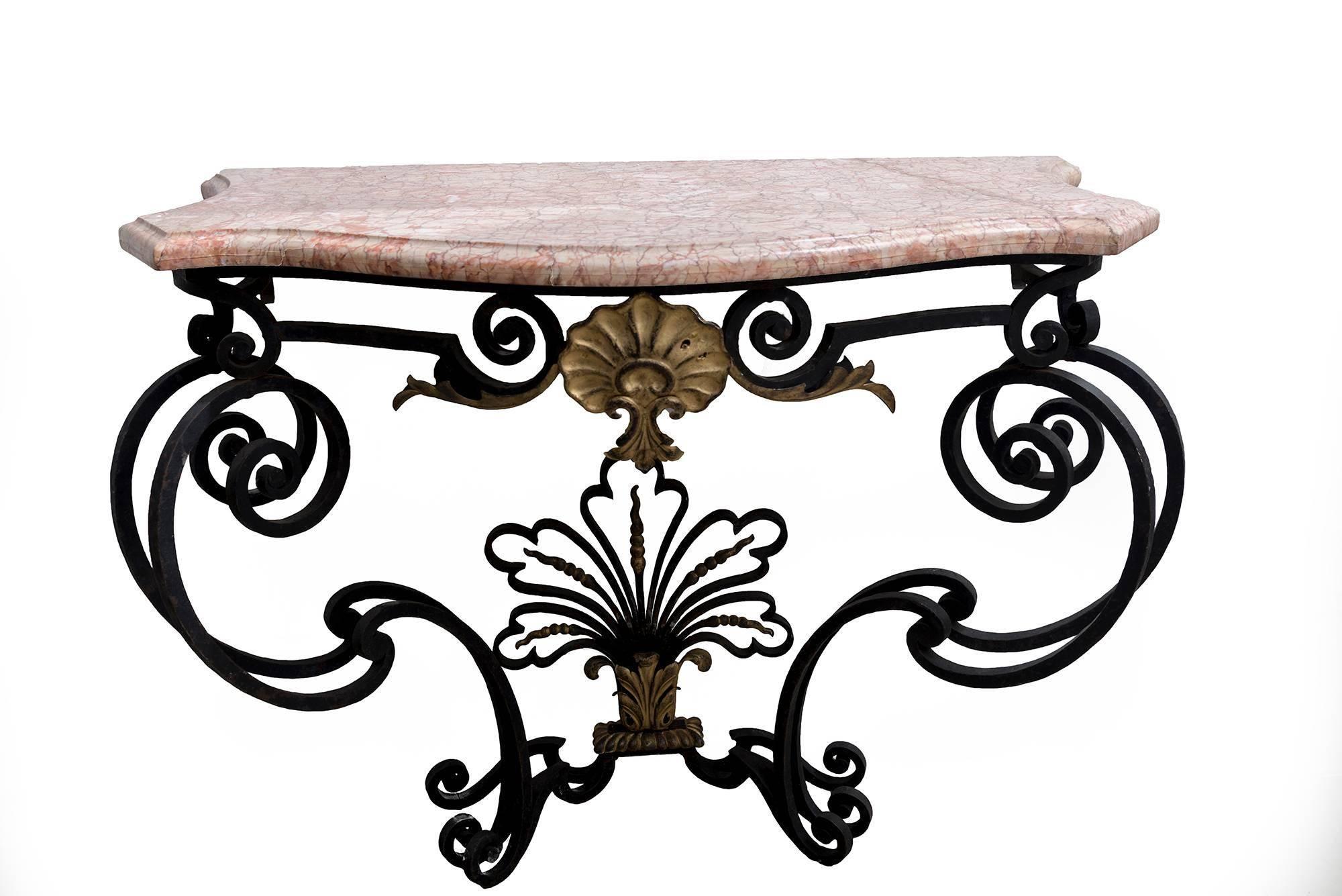 A beautiful natural wrought iron console table with pink marble top. Detail design underneath with gilt-work on wrought iron base.
