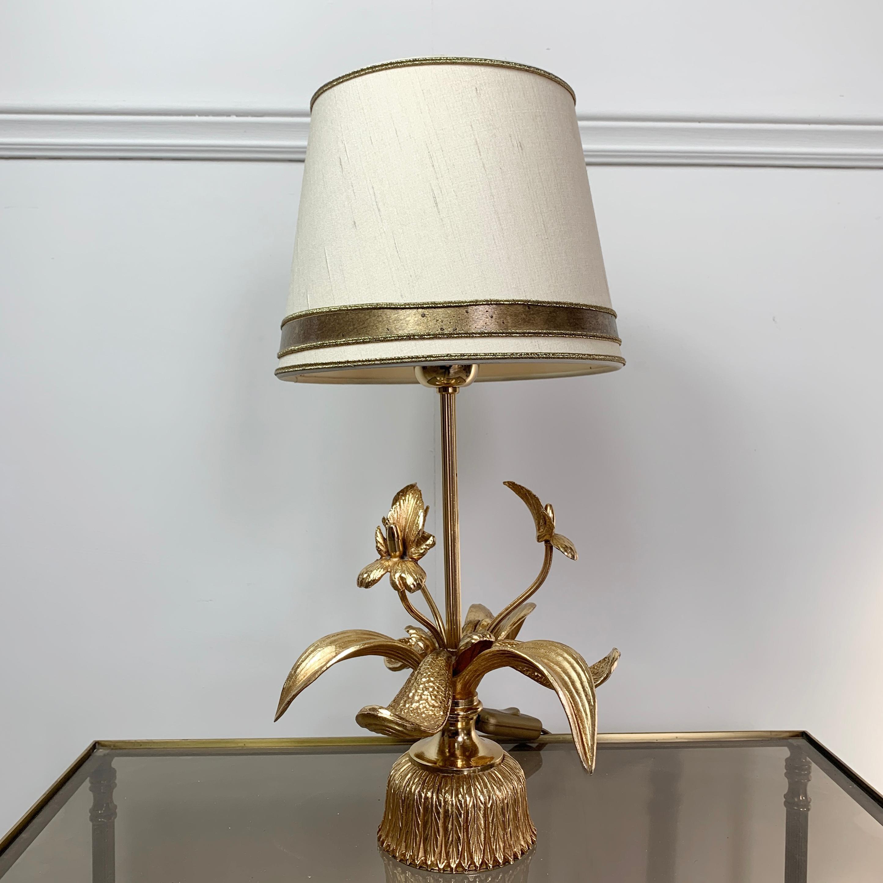 Gilt orchid table lamp, massive lighting, Belgium
circa 1970s
The lamp takes a single bulb, large screw fitting e27
Original soft cream and gilt lamp shade
Measures: 43cm height, 20cm width (shade)

The light is wired and in full working