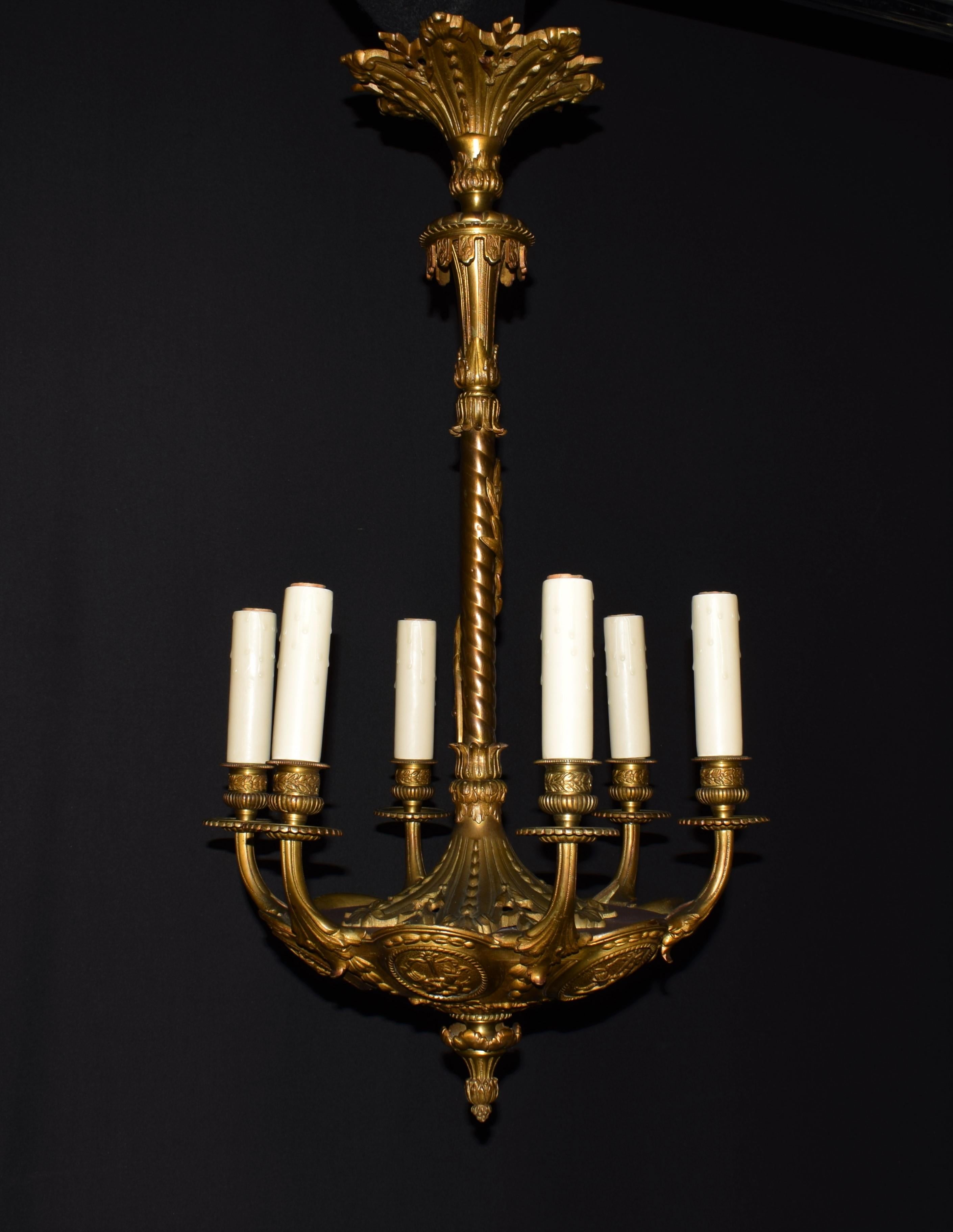 A fine gilt and patinated bronze chandelier. Great quality. Featuring oval reserves depicting crossed quivers and horns of plenty. France, circa 1910.

Dimensions:
H 28