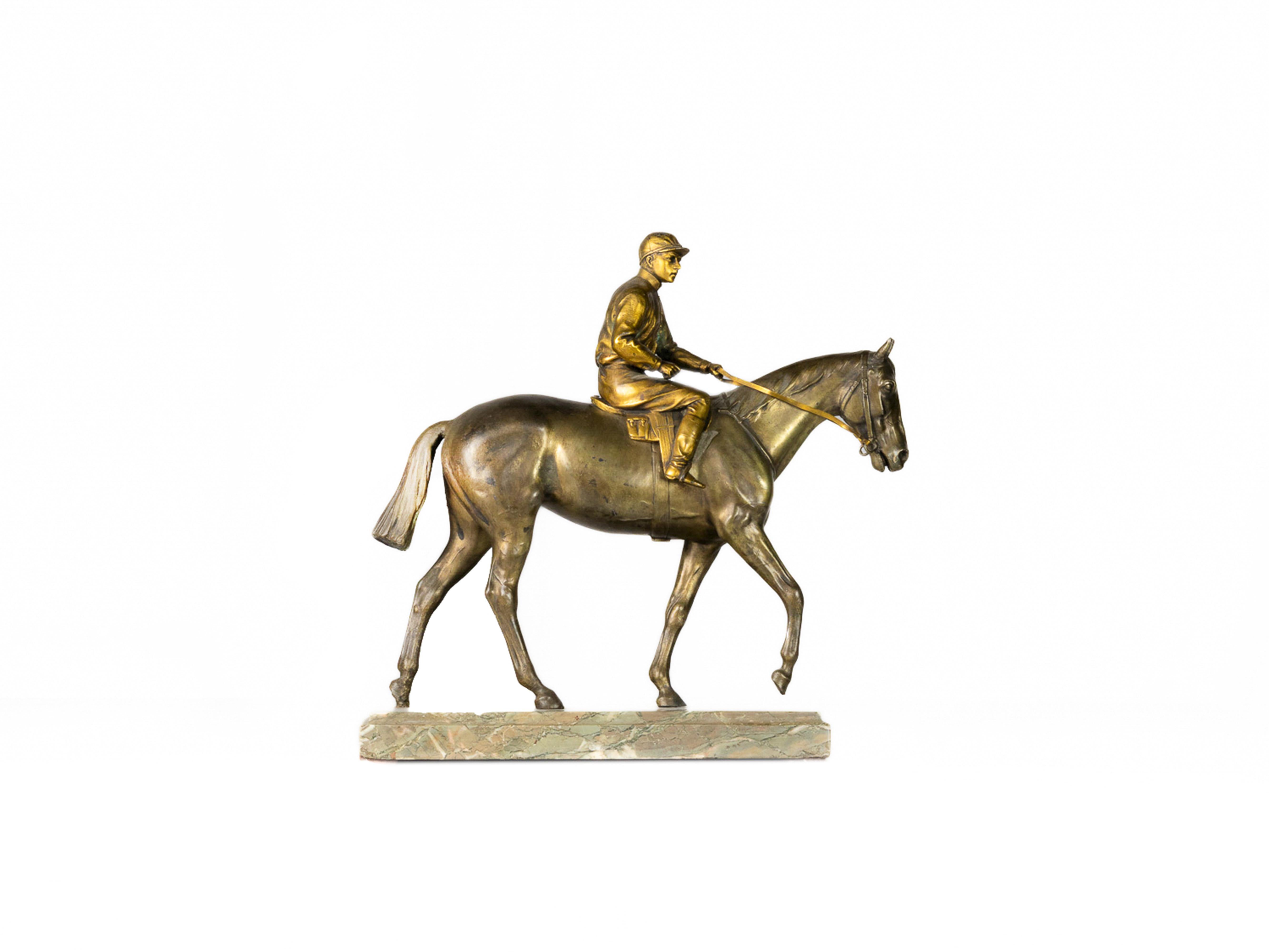 Sculpture de table française Jockey à Cheval de la période Napoléon III, en bronze doré et patiné, représentant un jockey et son fidèle cheval dans les moindres détails. 
La pièce repose sur un élégant socle en marbre.

Cette pièce équestre est une