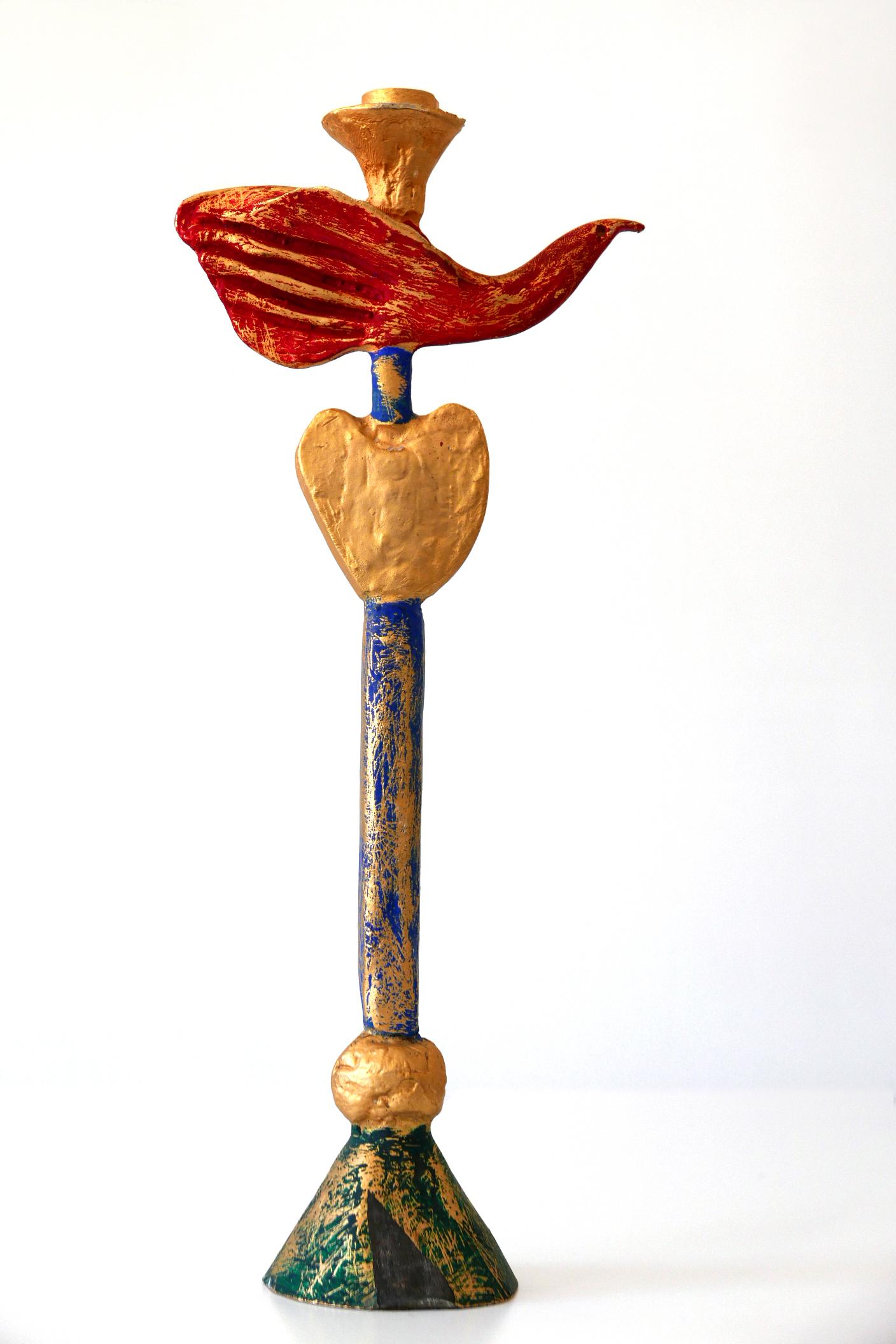 Here is a sculpture rather than a candleholder. Exceptional work by Pierre Casenove, 1980s, France.

Executed in gilt and polychrome (gold, red, blue and green) enameled bronze in shape of a dove.

Wear consistent with use and age. Unfortunately