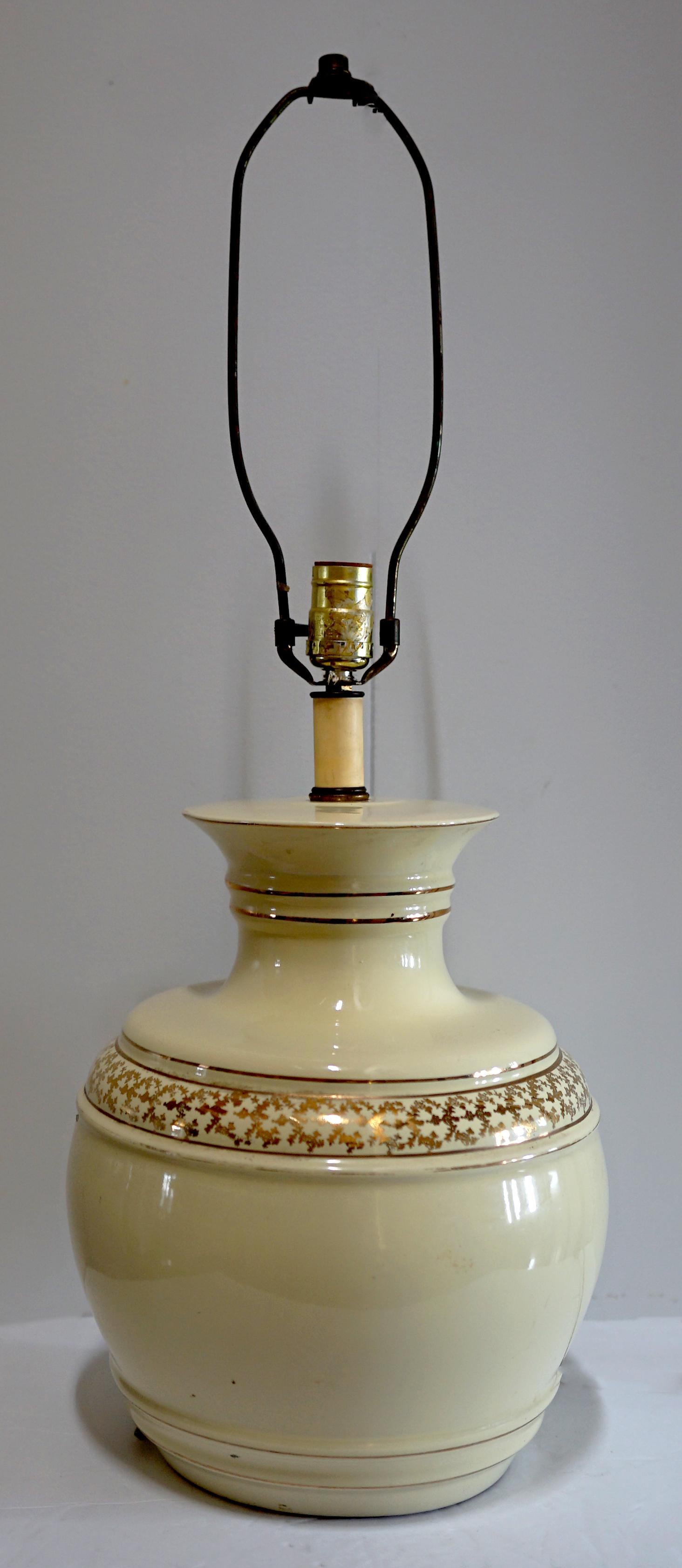 A band of delicate gold etching surrounds this lamp and creates a real sense of elegance and formality. A parcel gilt ceramic table lamp from the latter part of the 
20th Century. It works perfectly. It looks like it may have been hand painted and