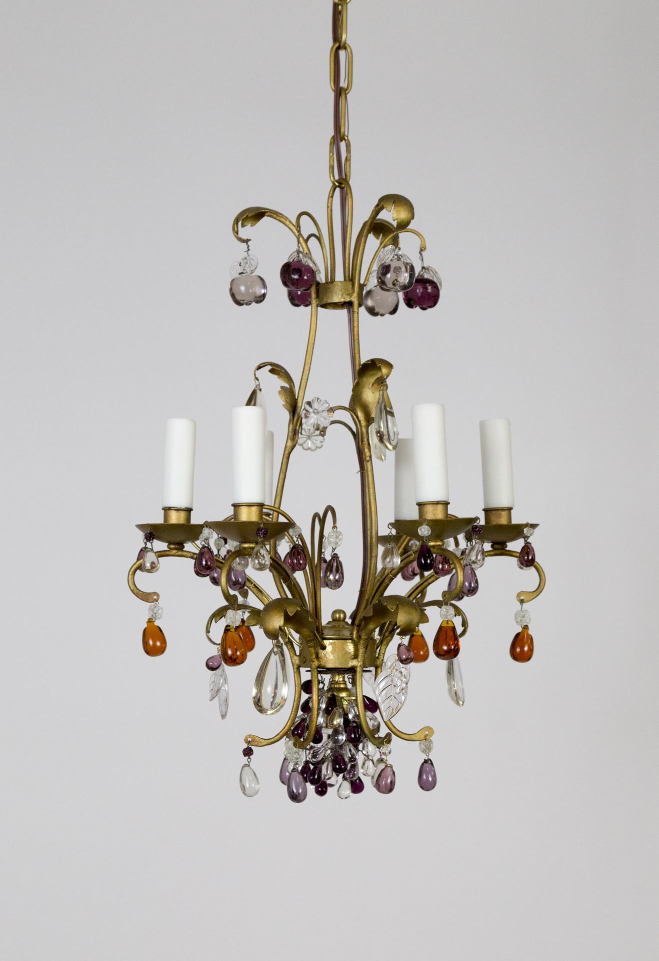 A gilt brass chandelier with dangling crystal fruit in amber, purple, amethyst, and clear. Apples hang from the crown and grape clusters at the bottom; with a downward socket within to illuminate them. It is a well-balanced shape, with 6 candlestick