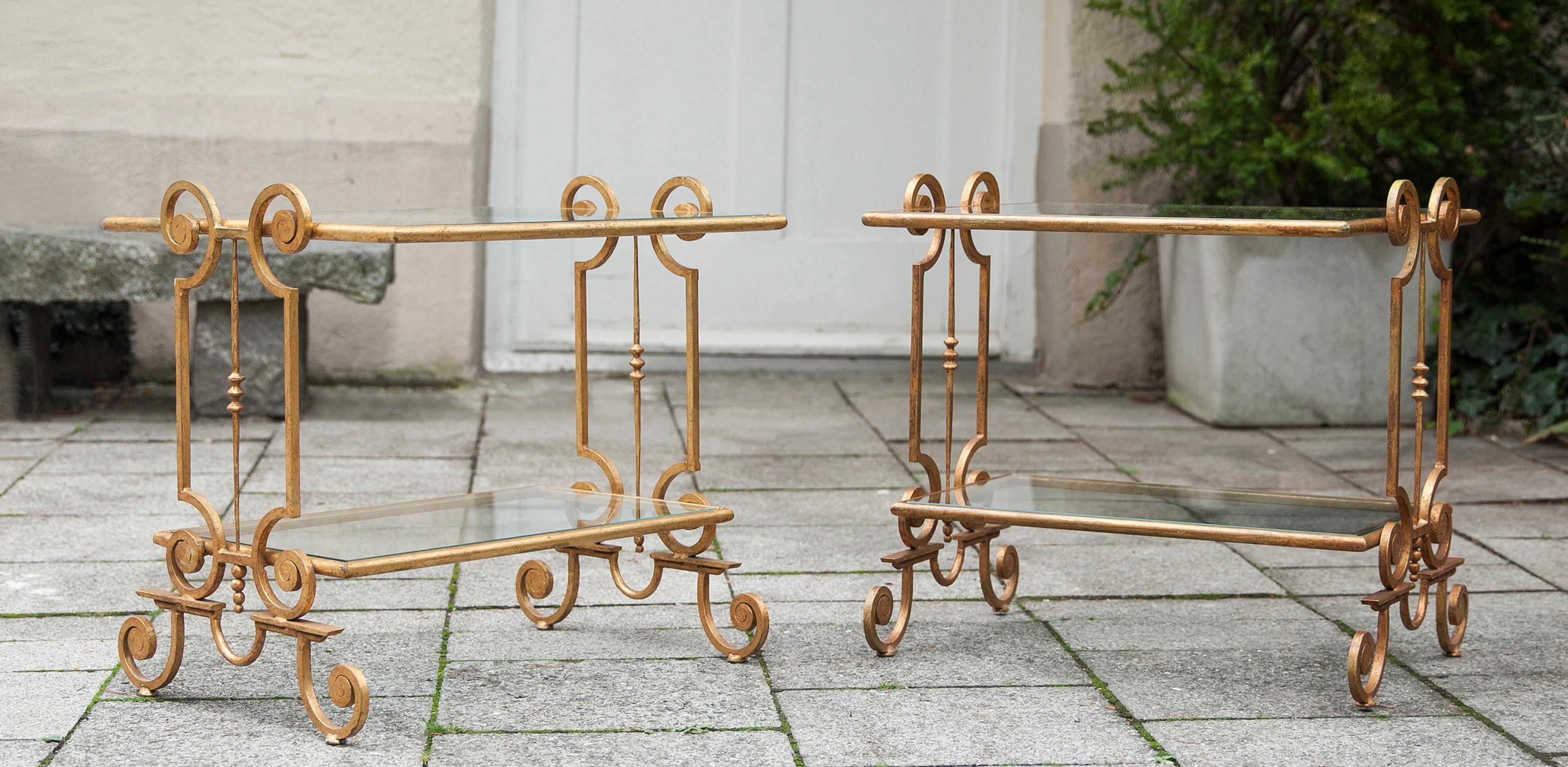 Elégantes tables d'appoint en fer doré de France des années 1960 avec deux plateaux en verre chacune.