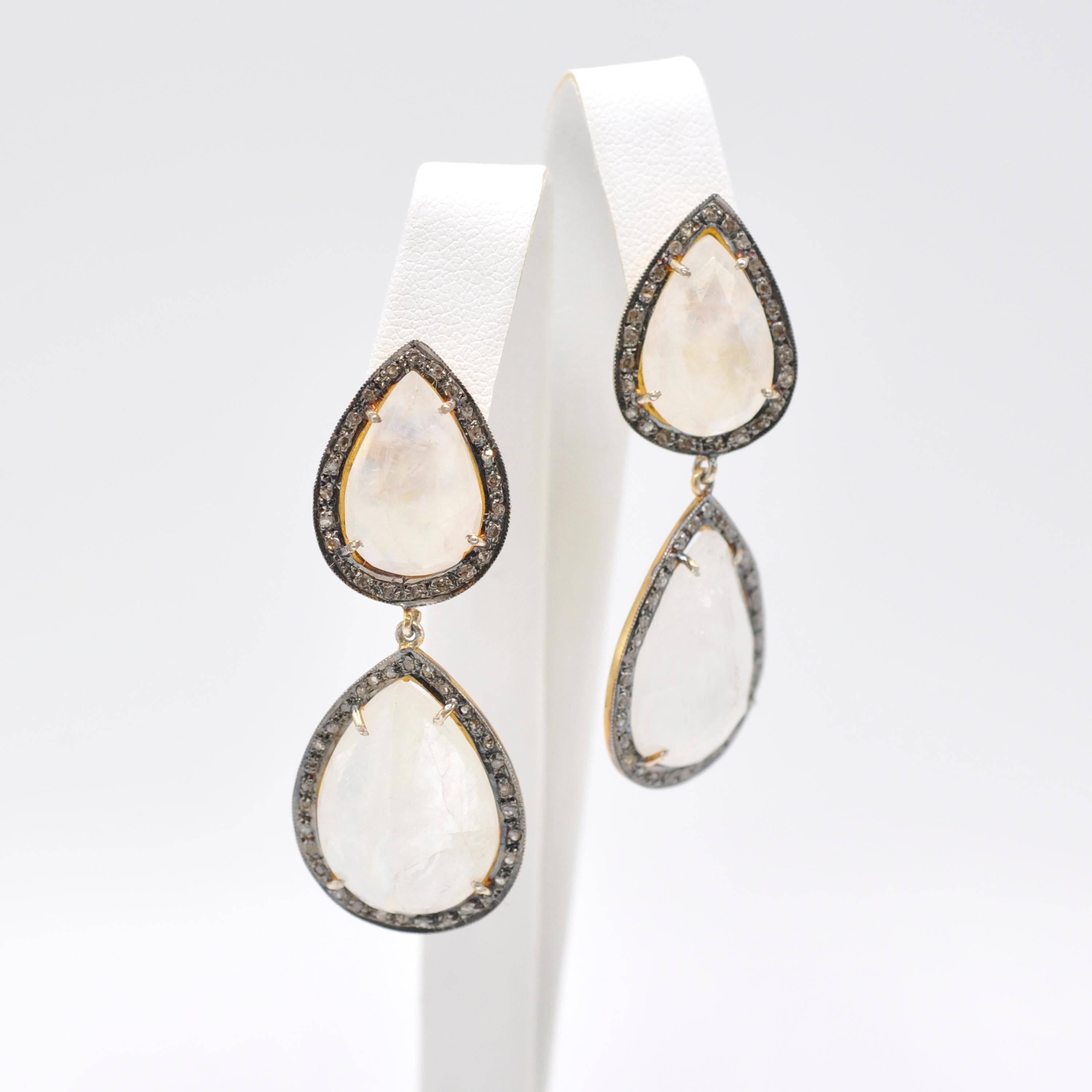 We love these bohemian moonstone earrings!

4 large pear shaped moonstones and .5 cts trillion cut diamonds set in silver that is gilt on the back of the earring so that silver shows on the front and gold on the back. The milky white moonstones