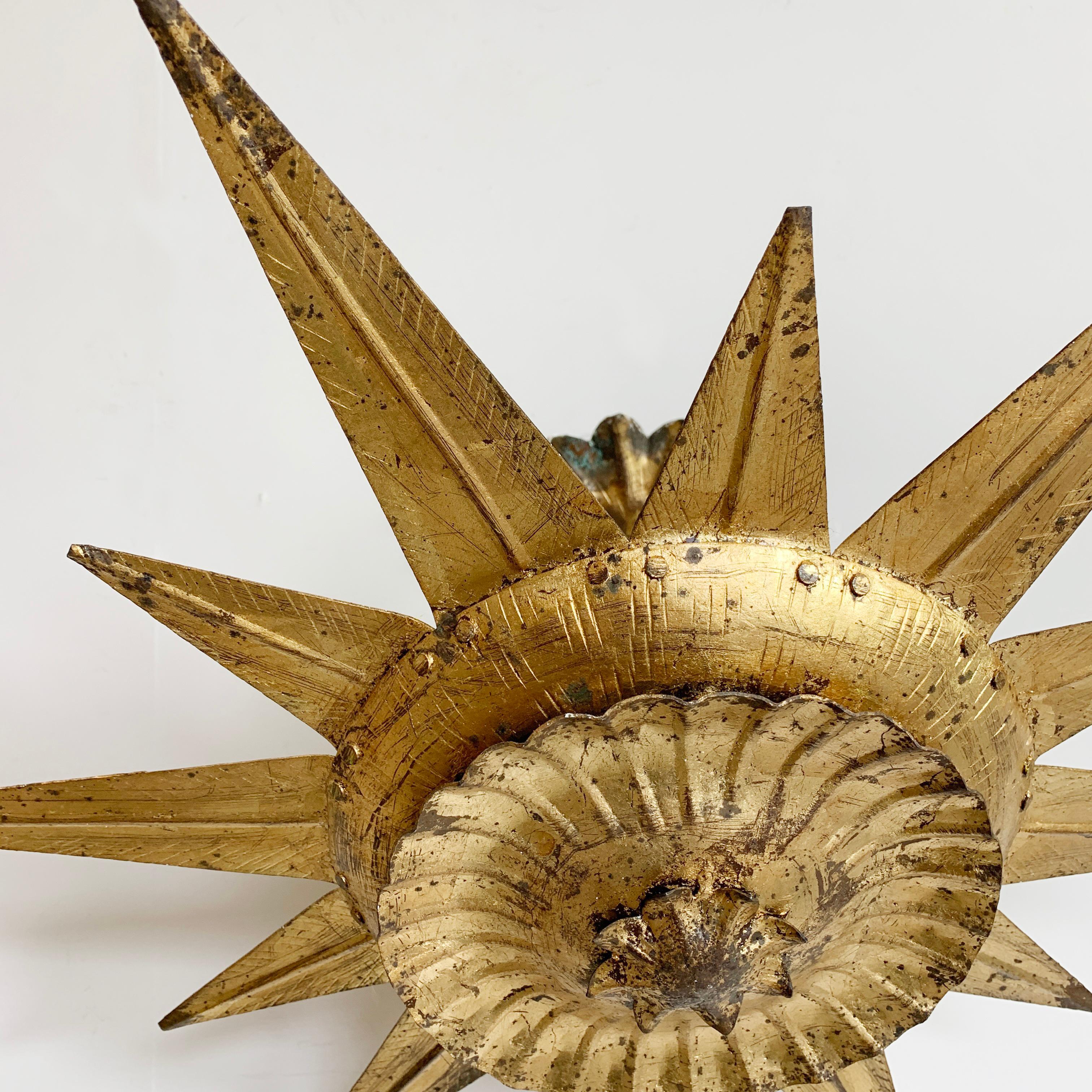 Beautiful gilt metal Spanish sunburst light, Spain, 1950's.
Original gilt finish
This is a beautiful and rare design
Large size sunburst ceiling light on a pendant stem
The light has a ceiling rose with 2 holes to attach the fixture to the