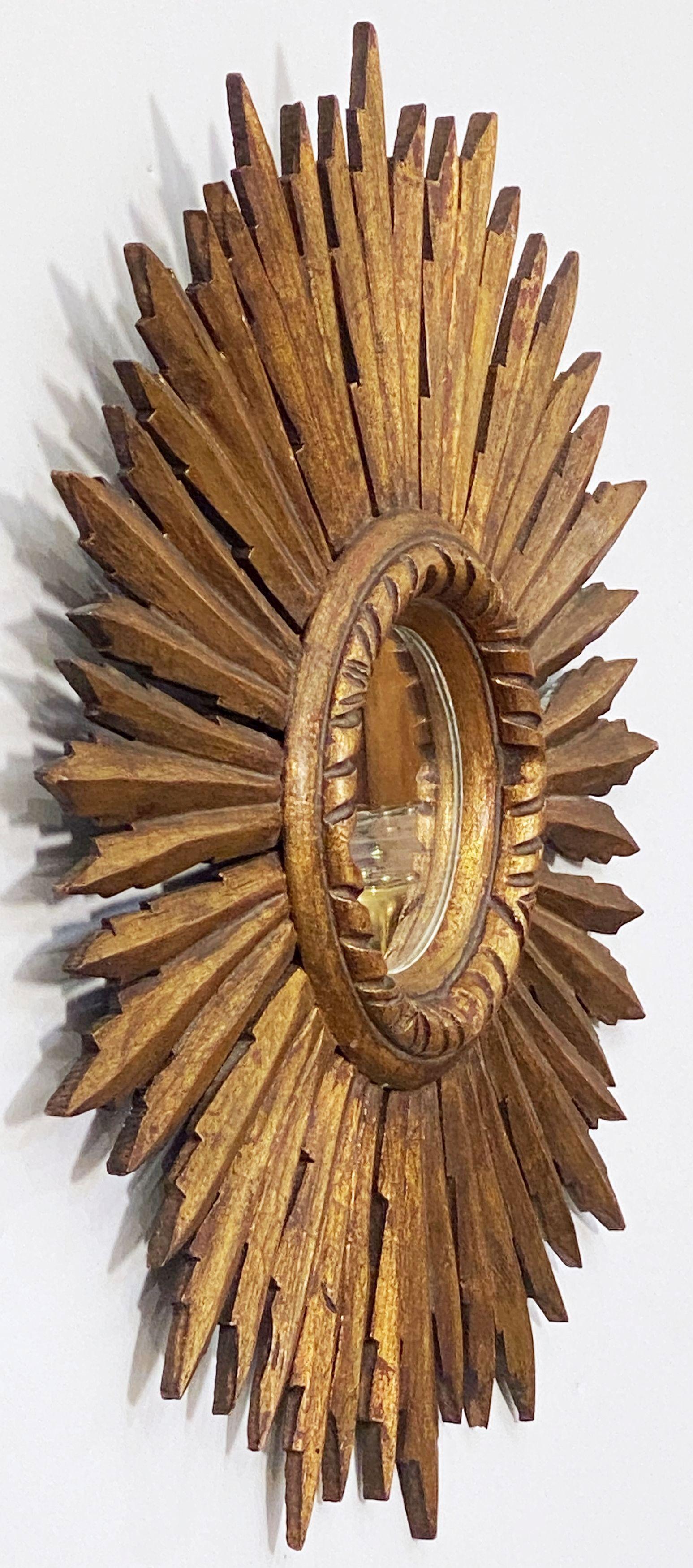 A lovely Spanish gilt sunburst or starburst mirror with circular mirrored glass center in carved frame.

Measure: Diameter of 18 inches
