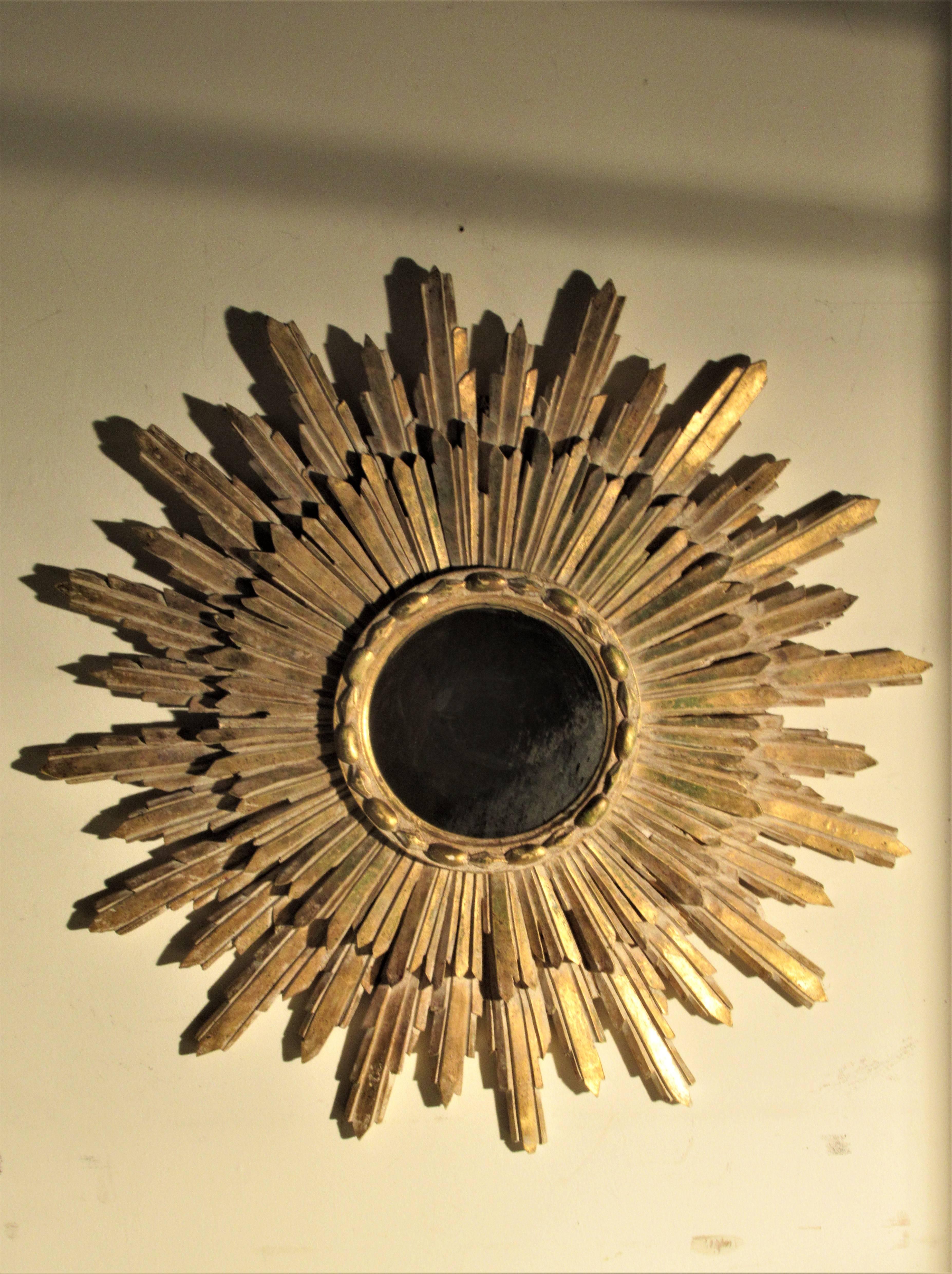 Solid and heavy plaster composite gilt sunburst starburst mirror in nice original lightly worn gilded surface with white washed highlights. Oxidation / crazing to circular mirror.  Circa 1960's - 1970's. Look at all pictures and read condition