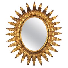 Miroir ovale doré Sunburst avec cadre feuillagé