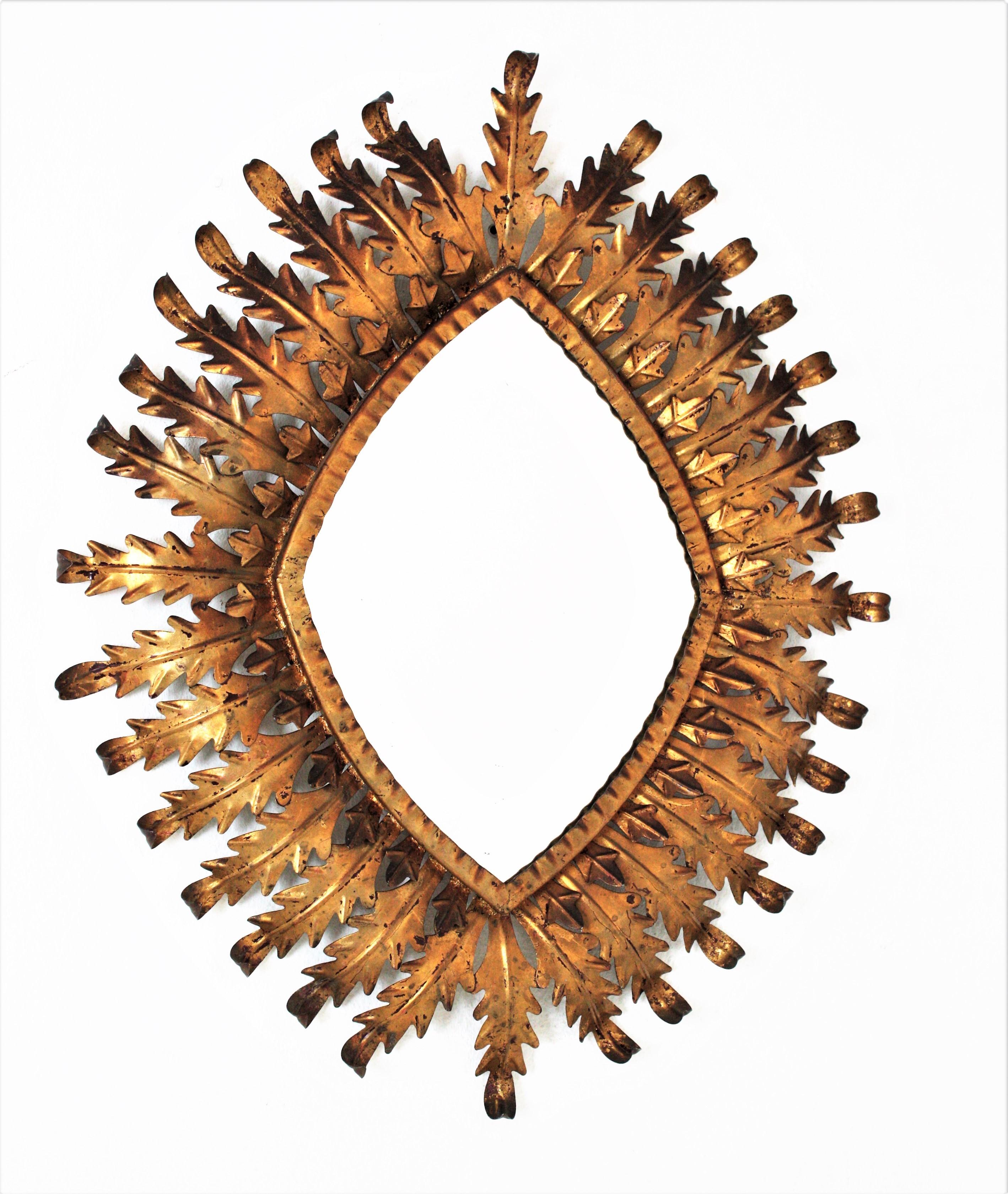 Foliage sunburst mirror, gilt iron, gold leaf. France, 1950s.
Hollywood Regency sunburst rhombus shaped mirror in gilt metal with double leafed frame. The frame is comprised by a layer of small leaves surrounding the glass and another layer of