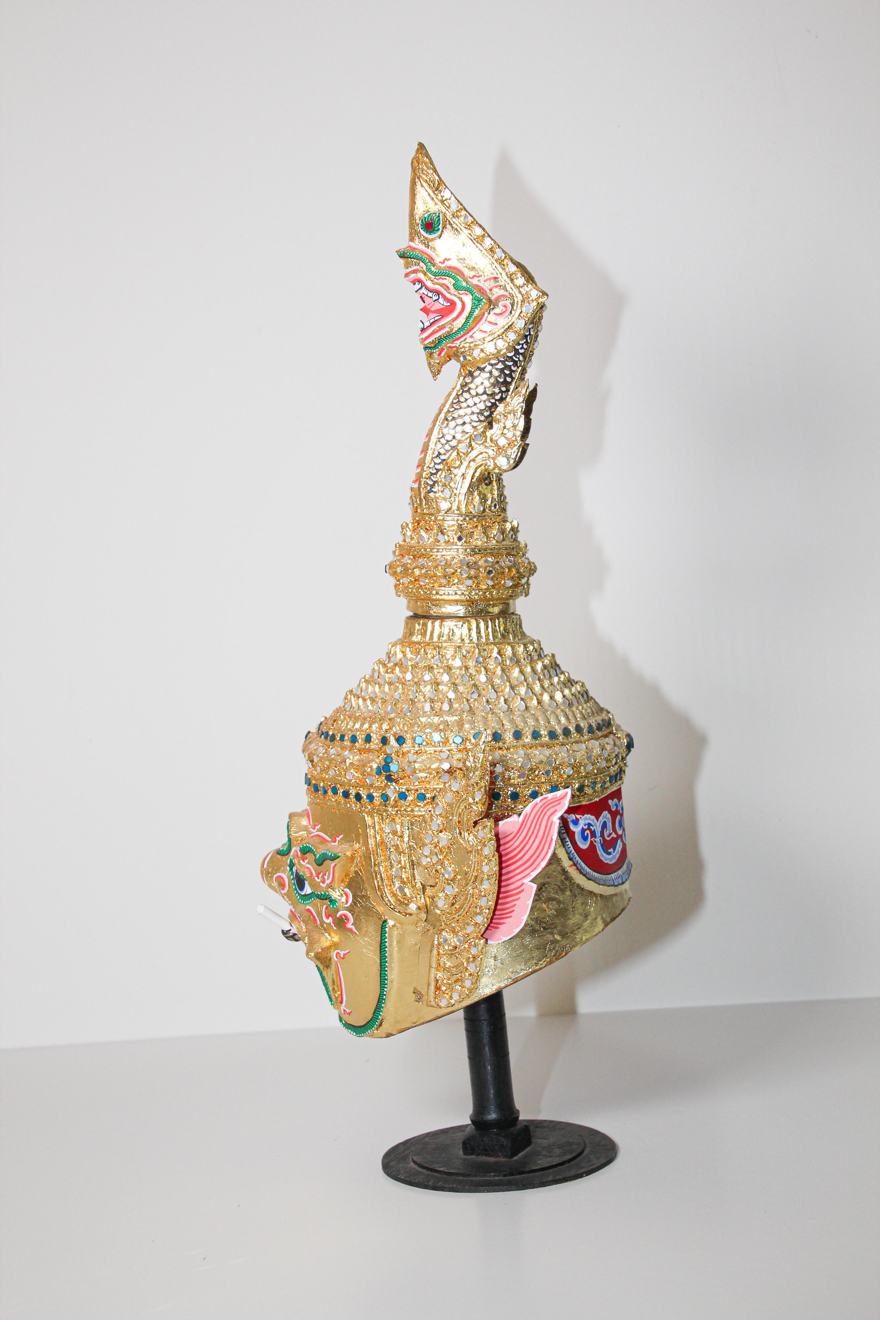 Handgefertigte vergoldete Thai Todsakhan Dämon Maske Tanz Kopfschmuck Krone Tänzer Kostüm auf Stand.
Handgefertigt aus Pappmaché, vergoldetem Metall und mit handgeschliffenem Glas verziert.
Großartiger traditioneller thailändischer
