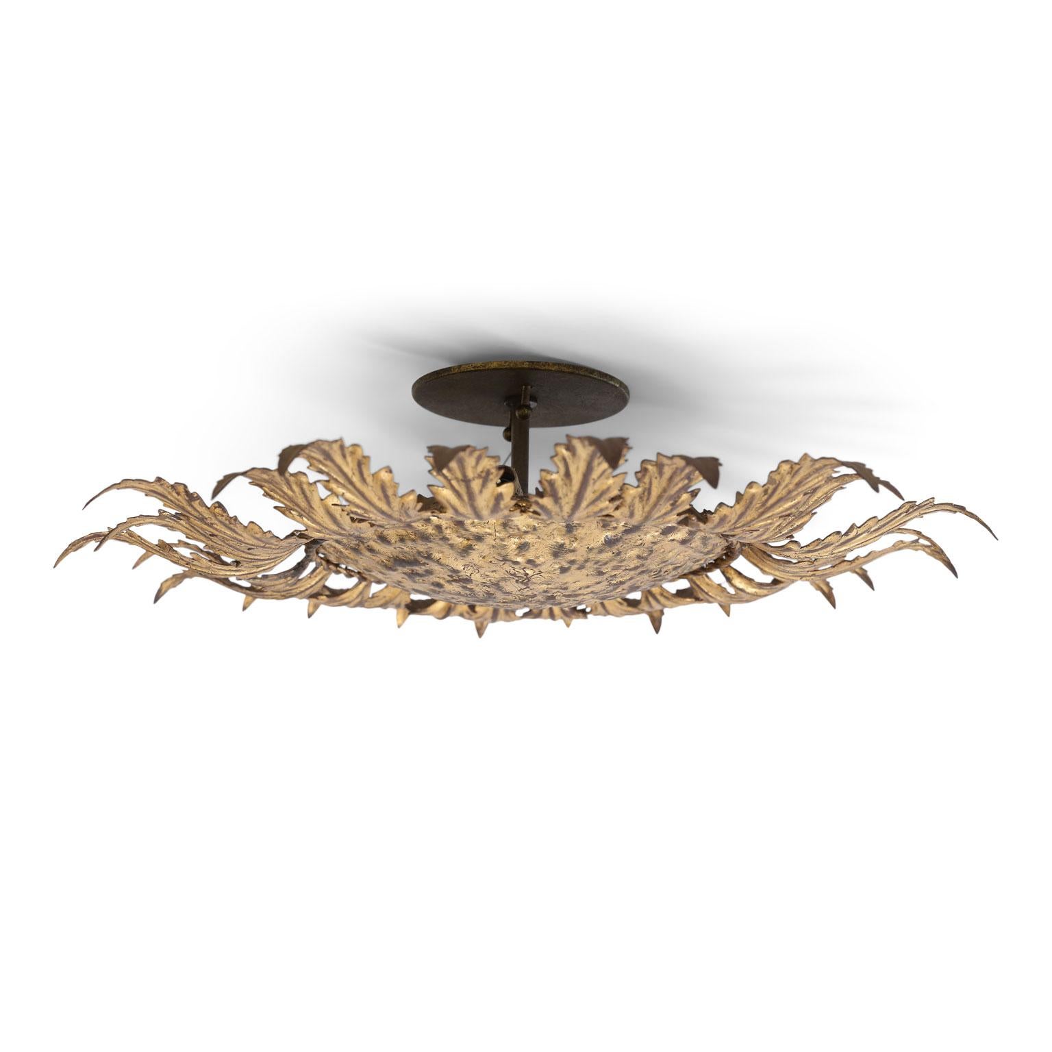Gilt tole flushmount light for your ceiling or wall. Sunburst design of gilt tole leaves radiating from a gilded hammered tole disc. This vintage Spanish light dates from circa 1950-1970 (Barcelona) and is newly wired for use within the USA.