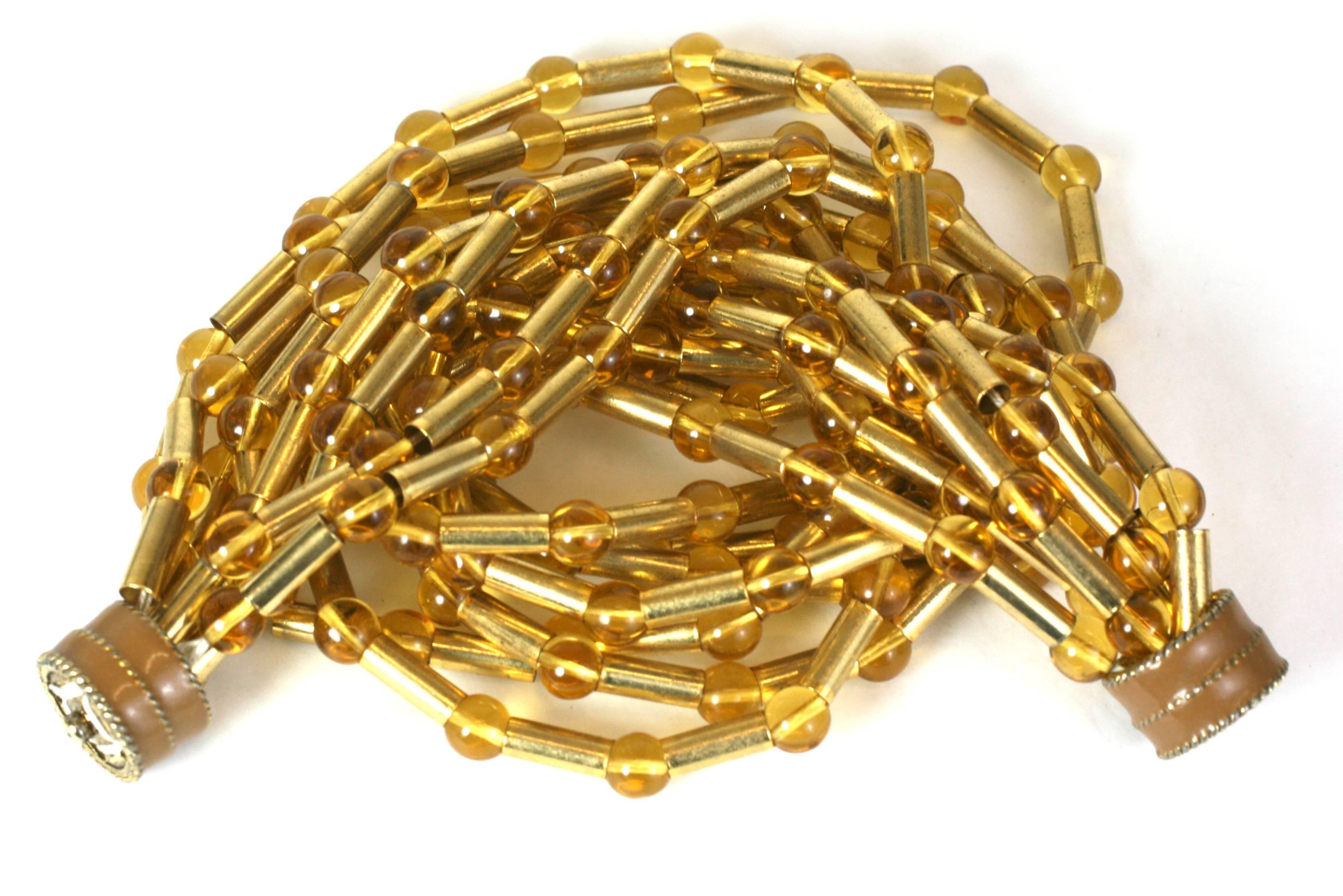 Attraente collana di perline dorate e Citrino degli anni '80. I tubi di metallo dorato sono intervallati da perline di vetro citrino con una chiusura a scatto smaltata di facile accesso.
USA. 1980's . Condizioni eccellenti.  
16