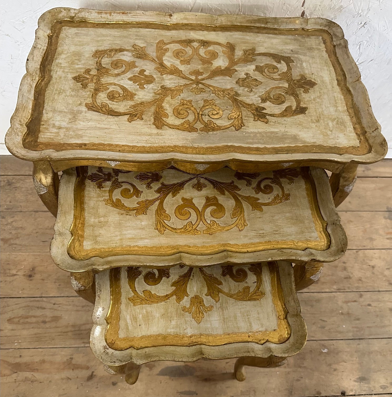 Set of three Florentine-style stacking tables featuring cabriole legs with intricate hand painted details on the tabletops and scalloped edges. The tables have been lovingly restored to its original condition but careful to retain the beautifully