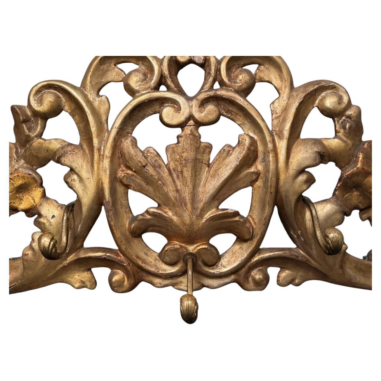 A rare carved and gilded wood coat stand (not the top of a trumeau, given the curved shape of the lower part) with five bronze hangers.
Italy, late 19th century .