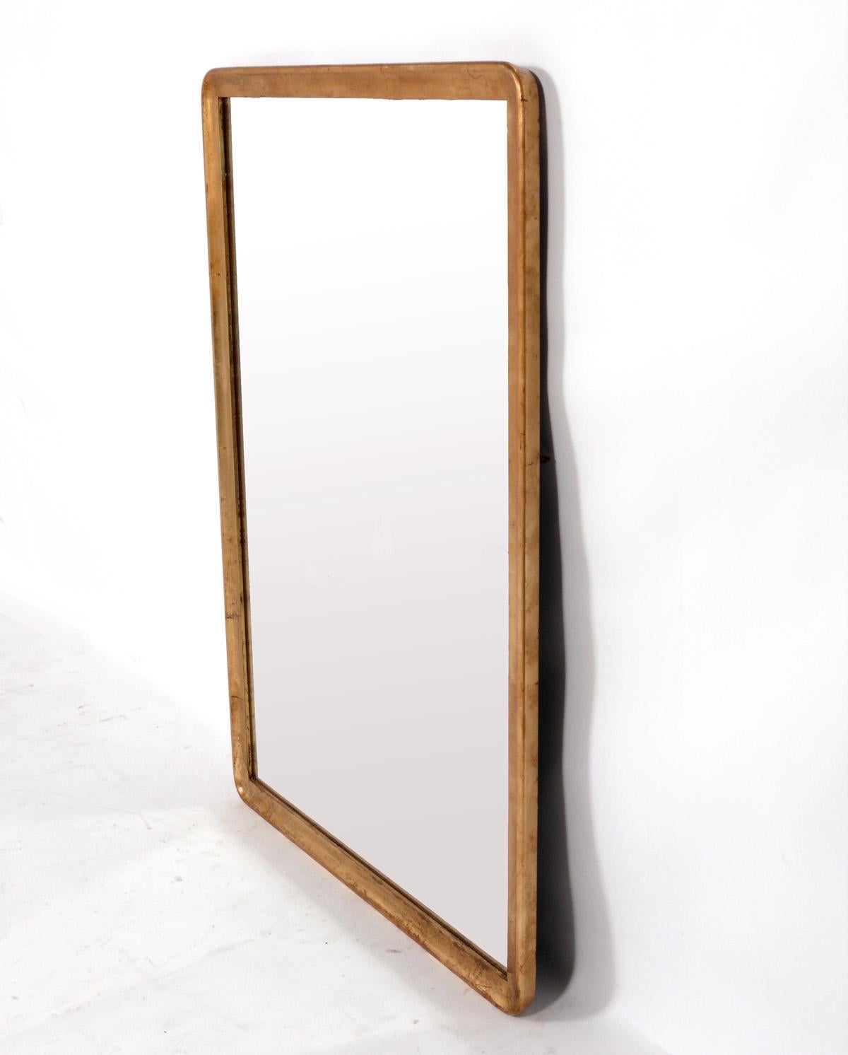 Gilt wood mirror, American, circa 1950s. Retains wonderful original patina to the gilt wood finish. It is an impressive size, measuring 46.5