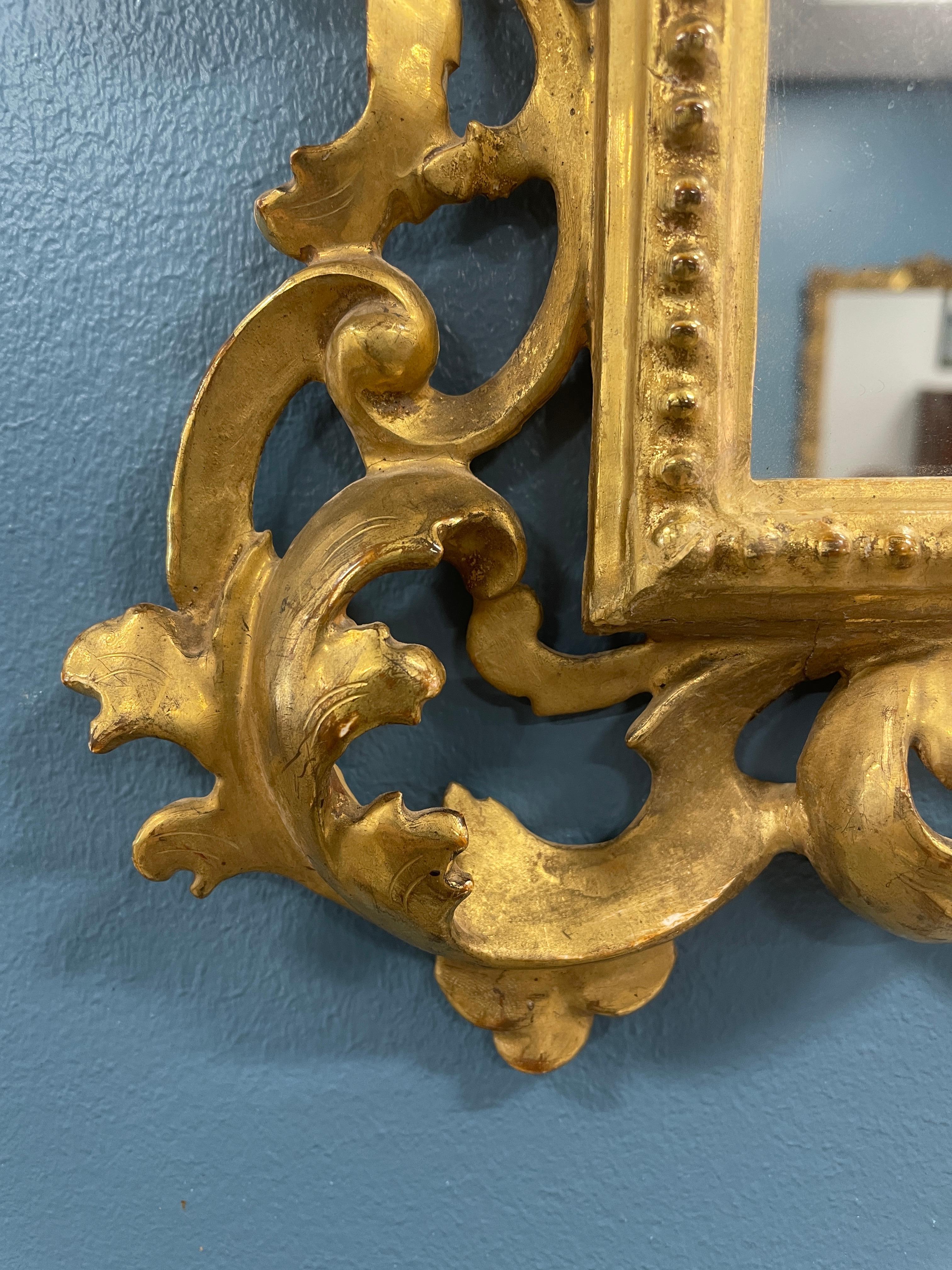 Entdecken Sie die Schönheit eines handgeschnitzten Wandspiegels aus vergoldetem Holz mit Akanthusblattdekor, der aus der Mitte des 19. Jahrhunderts stammt und in Deutschland gefertigt wurde. 

Erleben Sie die Anziehungskraft dieses exquisiten
