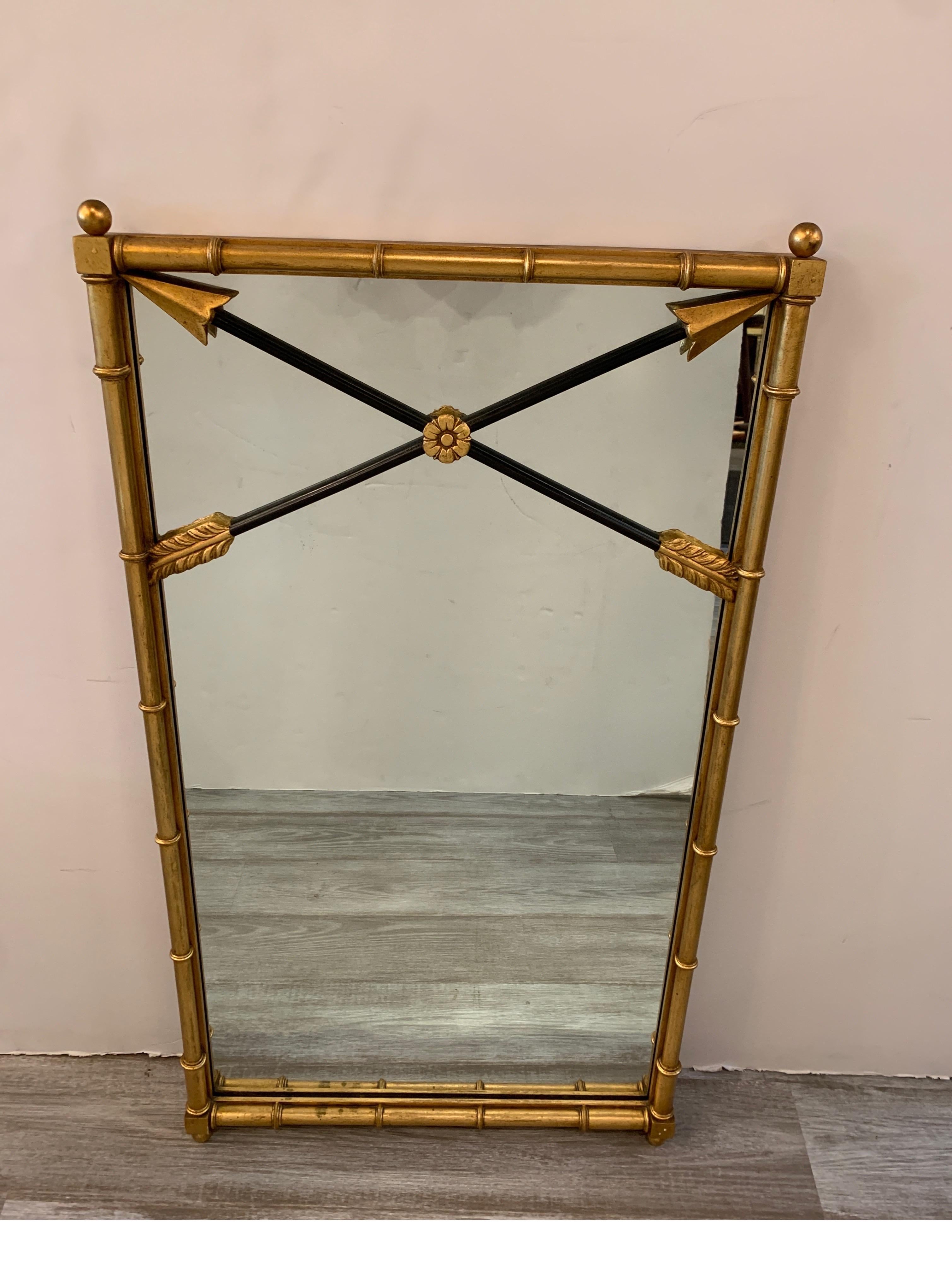 Elegant neoclassical giltwood mirror by Friedman Brothers NYC. The ringed gilt frame with crossed arrow top.