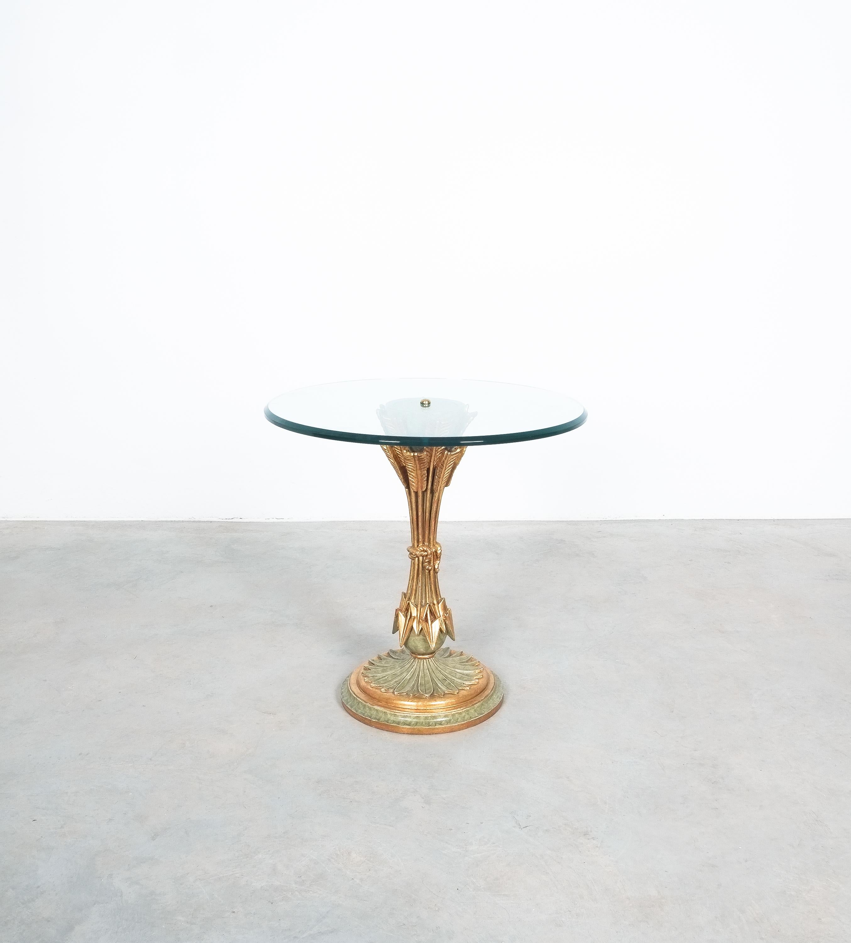 Nice gilt wooden side table, France, circa 1970

Well preserved and sized small center or side table in very good condition. The wooden base shows some bundled arrows pointing downwards. The thick center glass table top is in very good condition