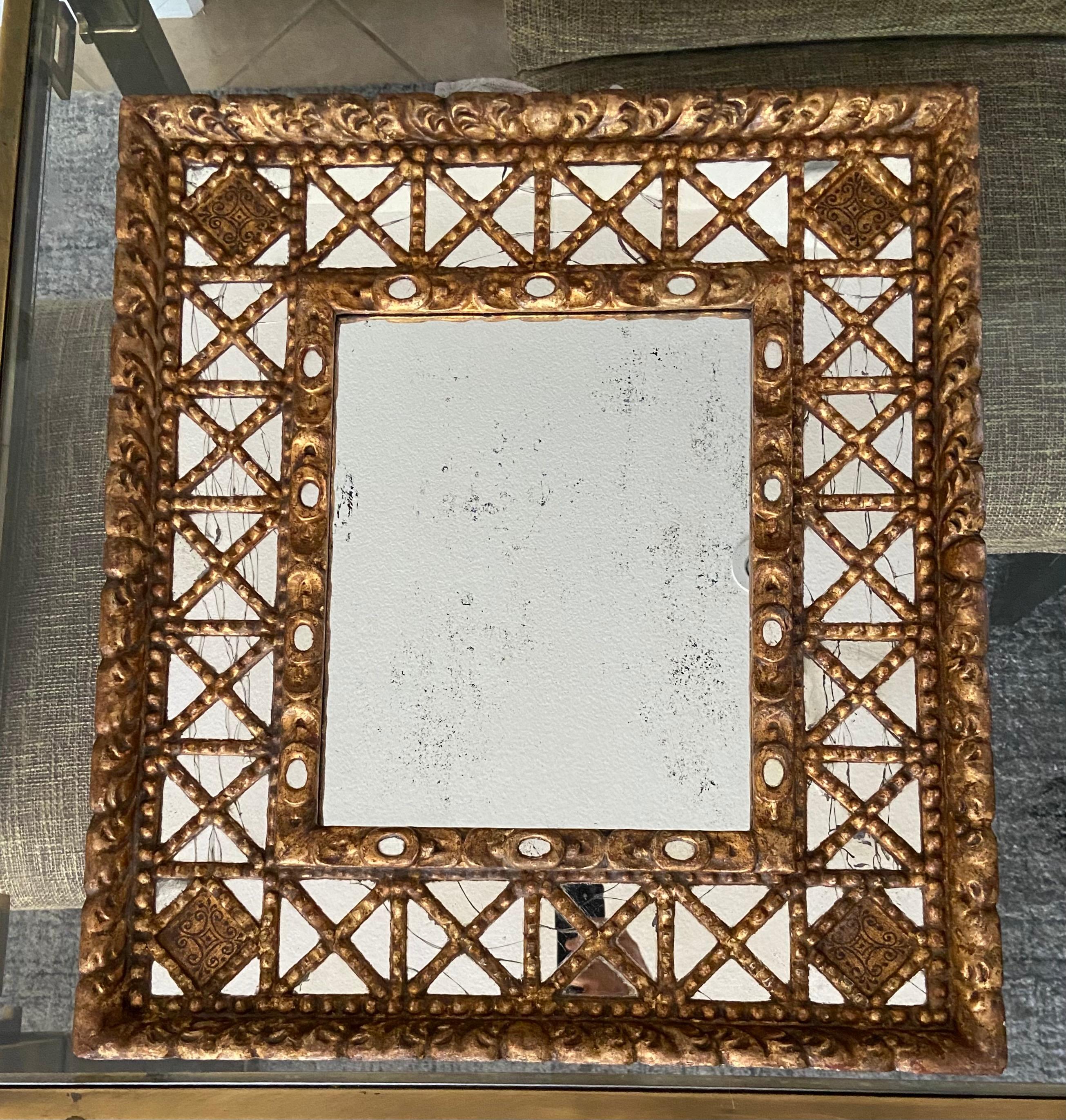 Handsome Spanish Colonial wall mirror in gold giltwood and gesso finish. Large center mirror has lots of antiqued age spots, smaller inset mirrors have a craquelure finish. Nice rustic detailing throughout. Slight rectangular shape.
The larger