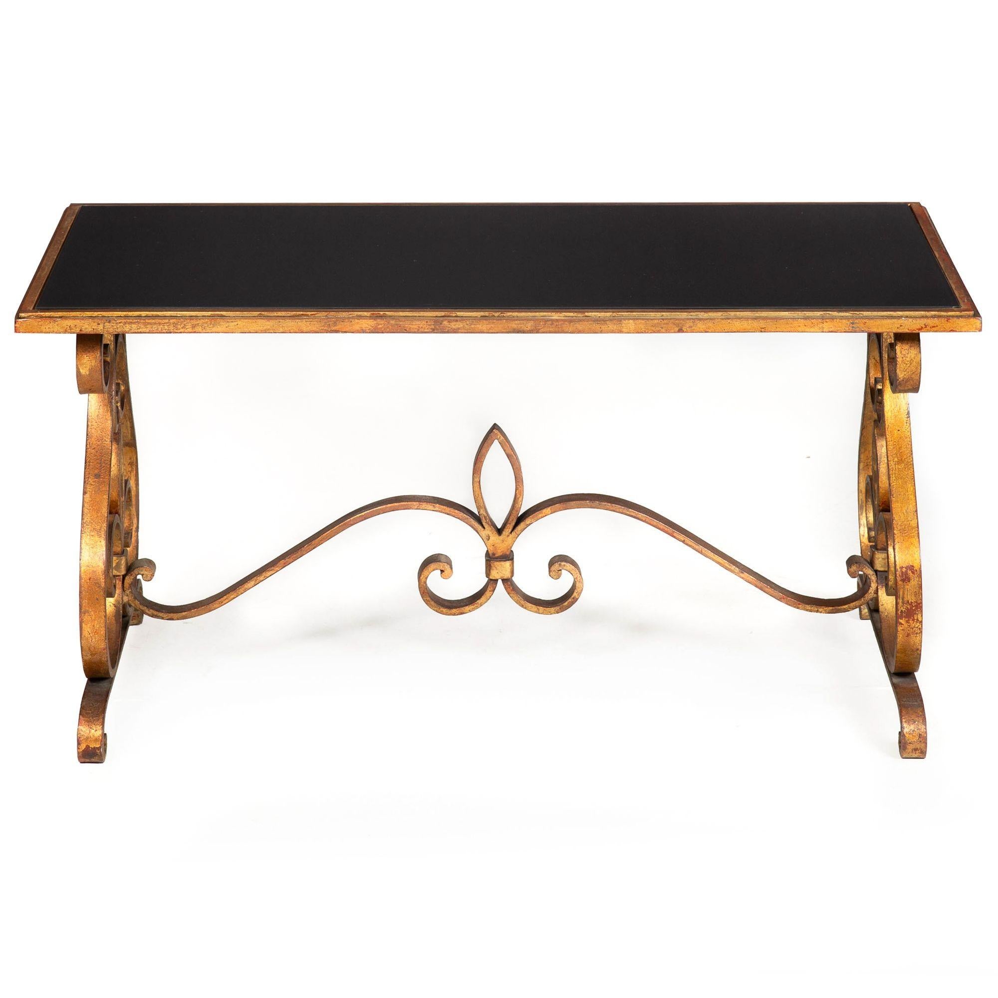 AN ELEGANT GILT AND POLYCHROMED WROUGHT IRON COCKTAIL TABLE
In the manner of Raymond Subes, France circa 1940s, unmarked

18 1/8
