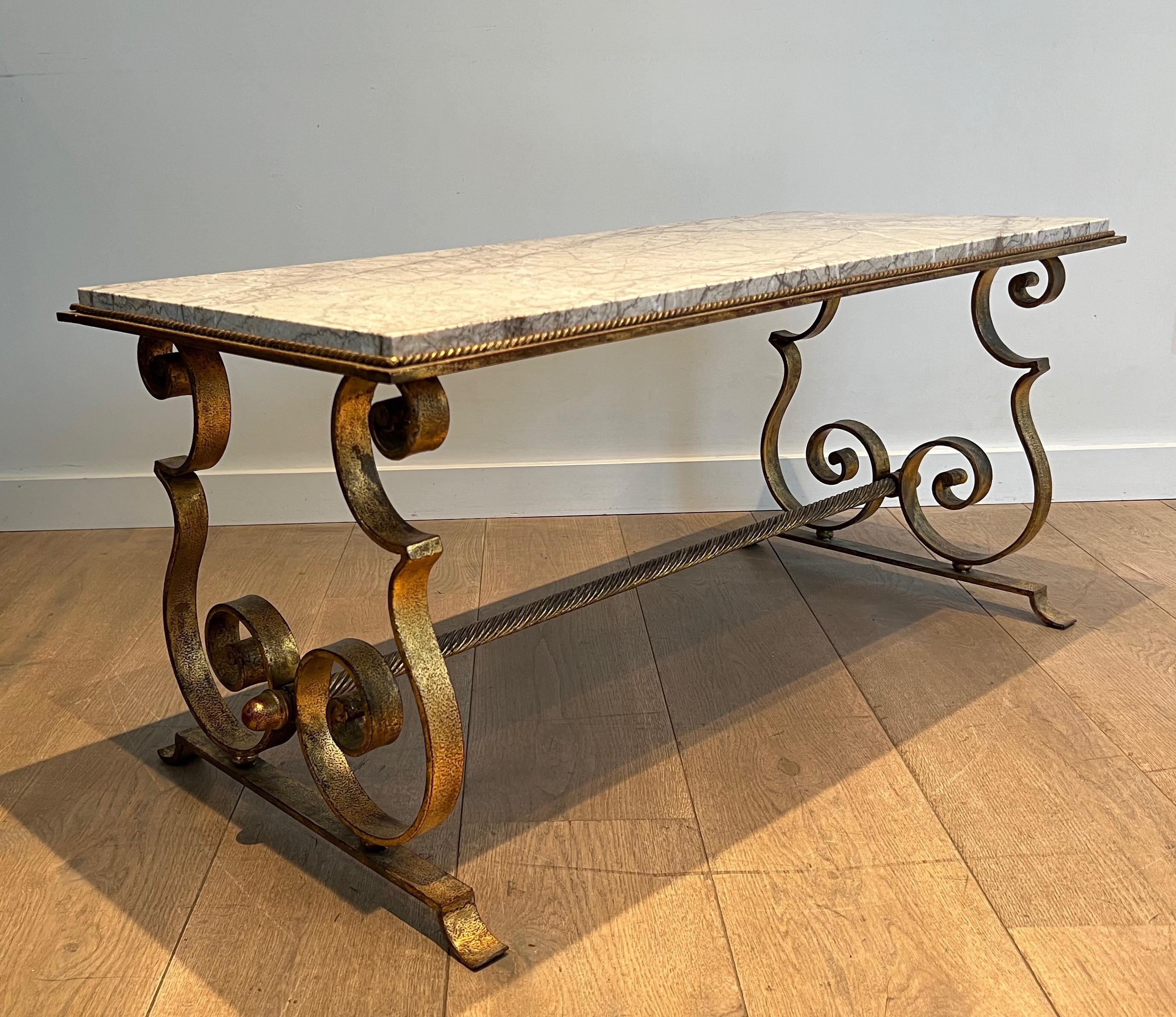 This very elegant coffee table is made of gilt wrought iron with a marble top. This is a French work. Circa 1940
