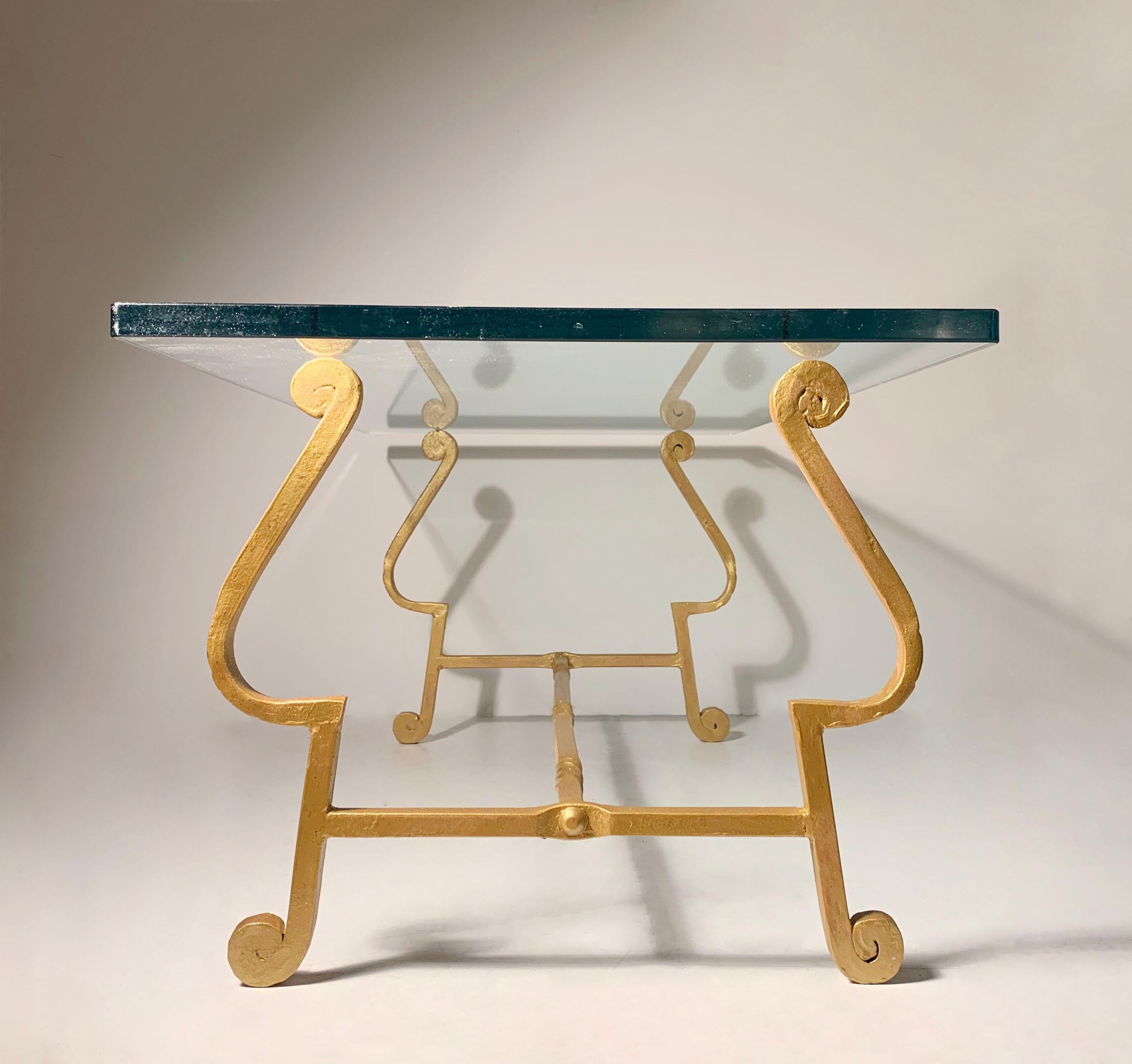 A nice vintage coffee table made in Spain. Dates to the mid-century. Nice coil work with hammered design. In the manner of Maison Ramsay, Gilbert Poillerat

Base was recently repainted with Gold over a red primer.

High end thick glass top is