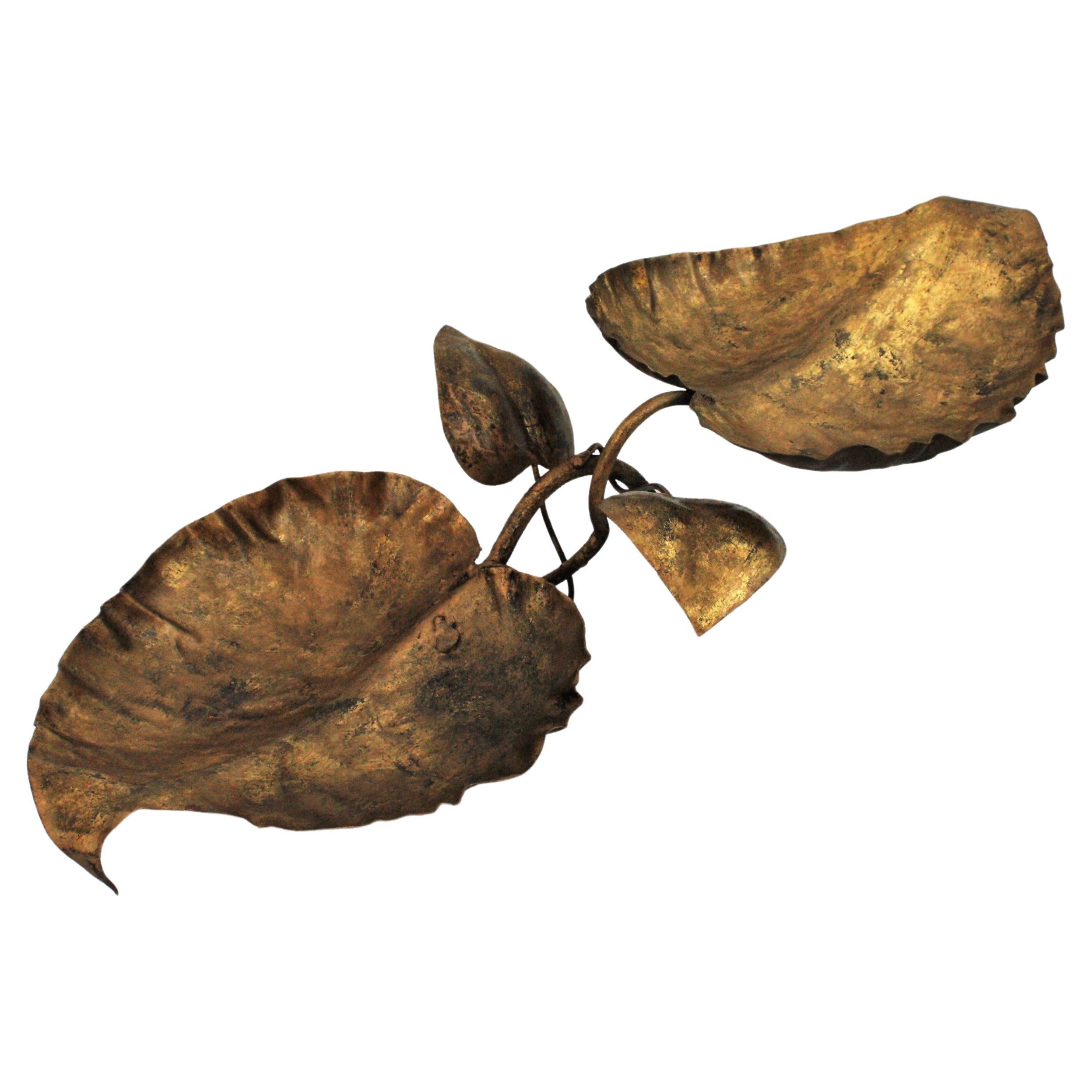 Hollywood Regency Foliage centerpiece in gilt iron, France, 1950s.
One of a kind decorative handcrafted centerpiece featuring two branches holding two large leaves as platters or vide-poches and two smaller leaves as decorative details.
It has a
