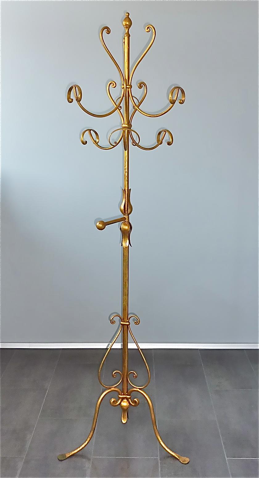 A gorgeous Italian midcentury gilt wrought iron metal coat stand or hat rack in the style of Hans Kögl, Italy, circa 1950s. The coat stand which has an upper width of about 43 cm / 16.93 inches and a lower stand width of 60 cm / 23.62 inches and