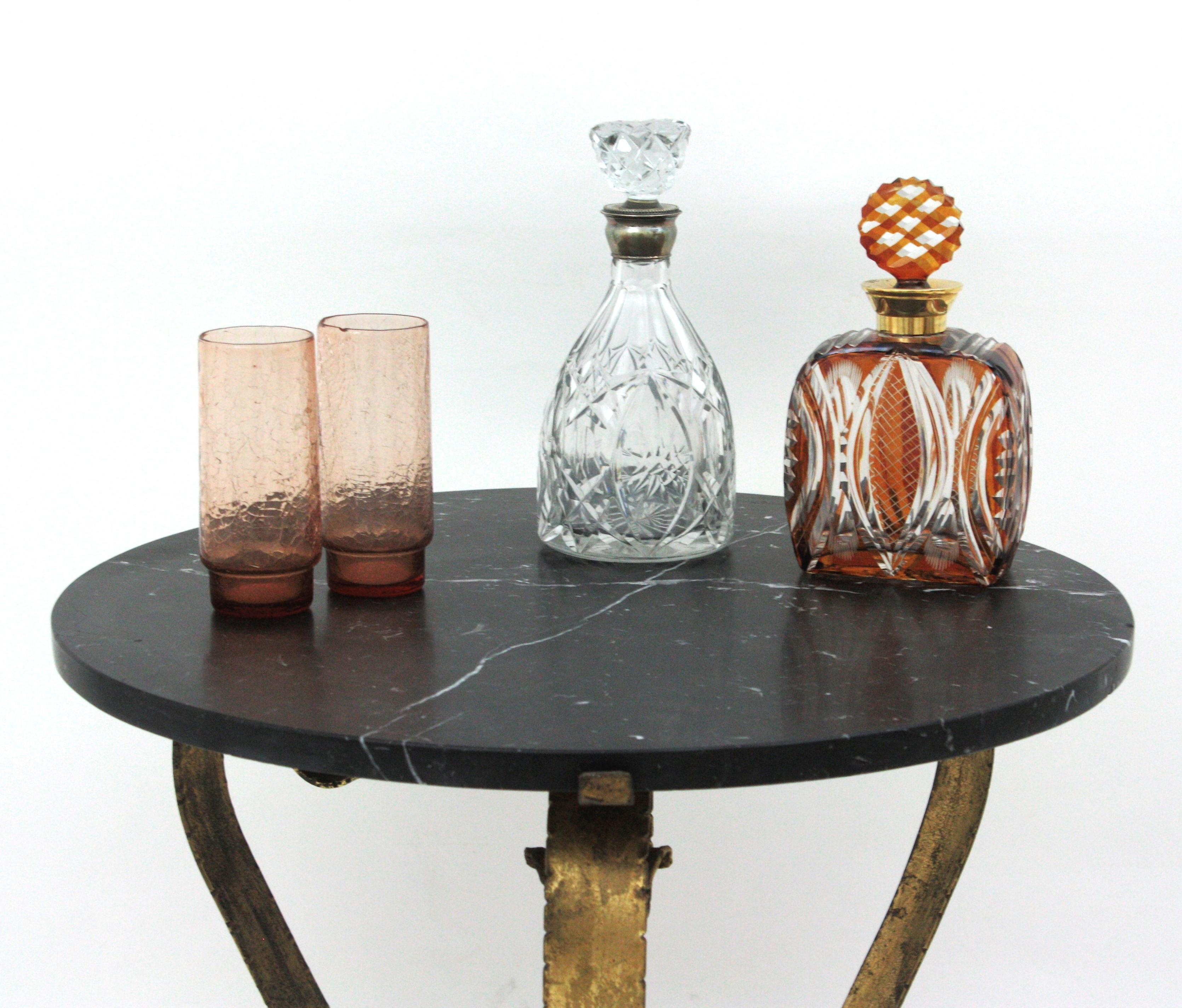 Espagnol Table basse ronde en fer forgé doré avec plateau en marbre noir en vente