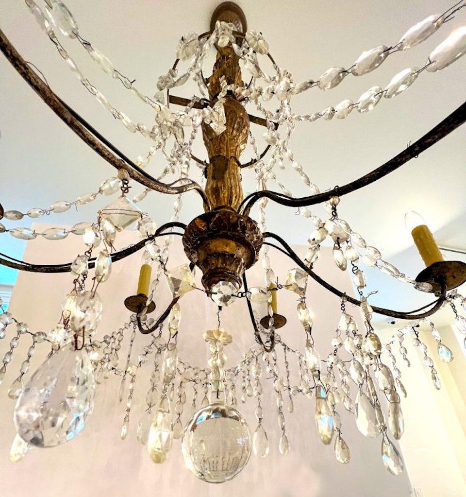 18th Century Italian gilt and crystal chandelier. Dramatic six-light gilded wood chandelier from Genoa, Italy. Beautiful antique crystal and iron detail with crystal rosettes.
Rewired for US use, however, not UL approved, so should be rewired.
