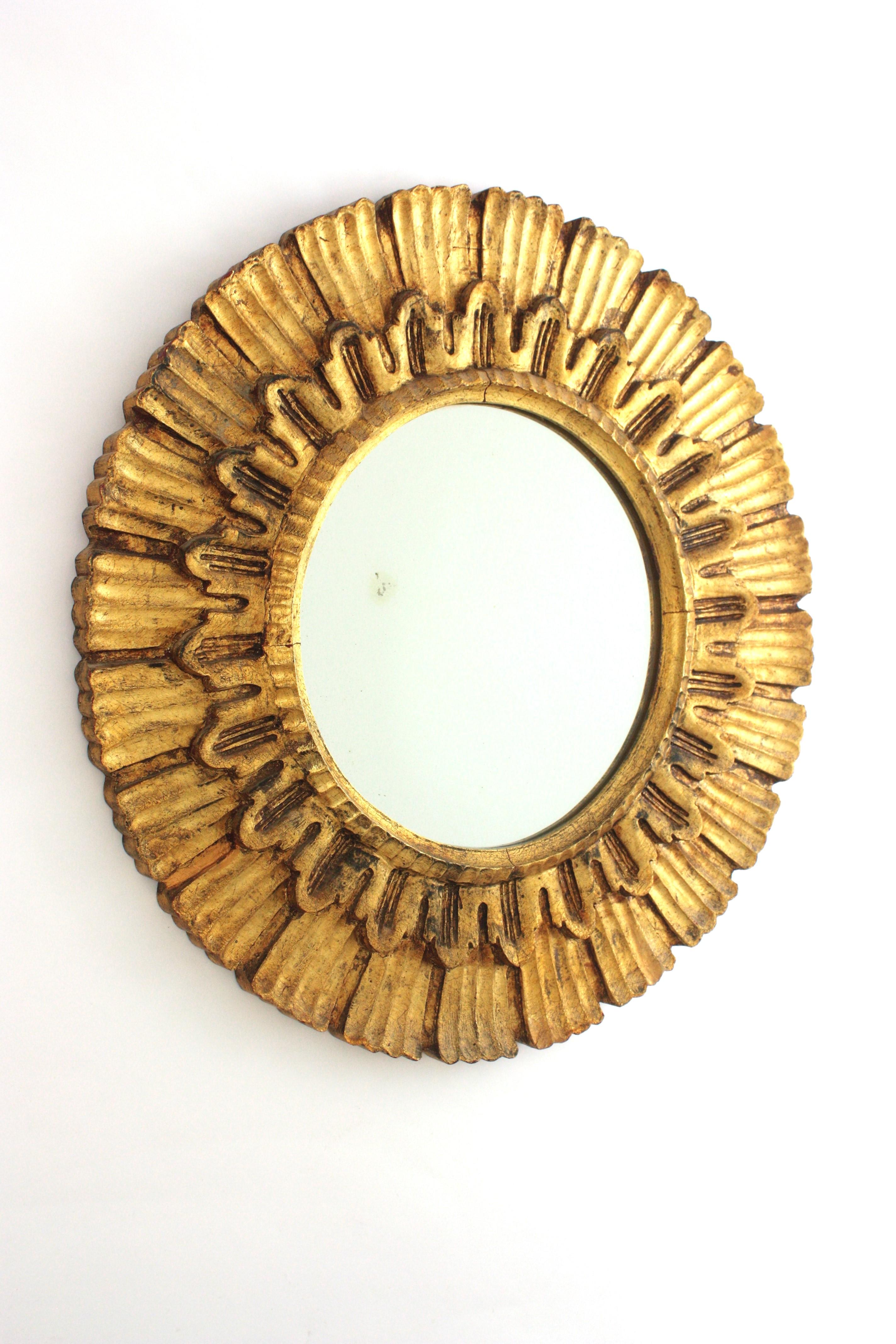Specchio rotondo a raggiera, legno intagliato, foglia d'oro, Spagna, anni 1950.
Questo specchio a raggiera è stato realizzato a mano con legno intagliato e doratura a foglia d'oro. Un design accattivante che combina accenti barocchi, Midcentury e