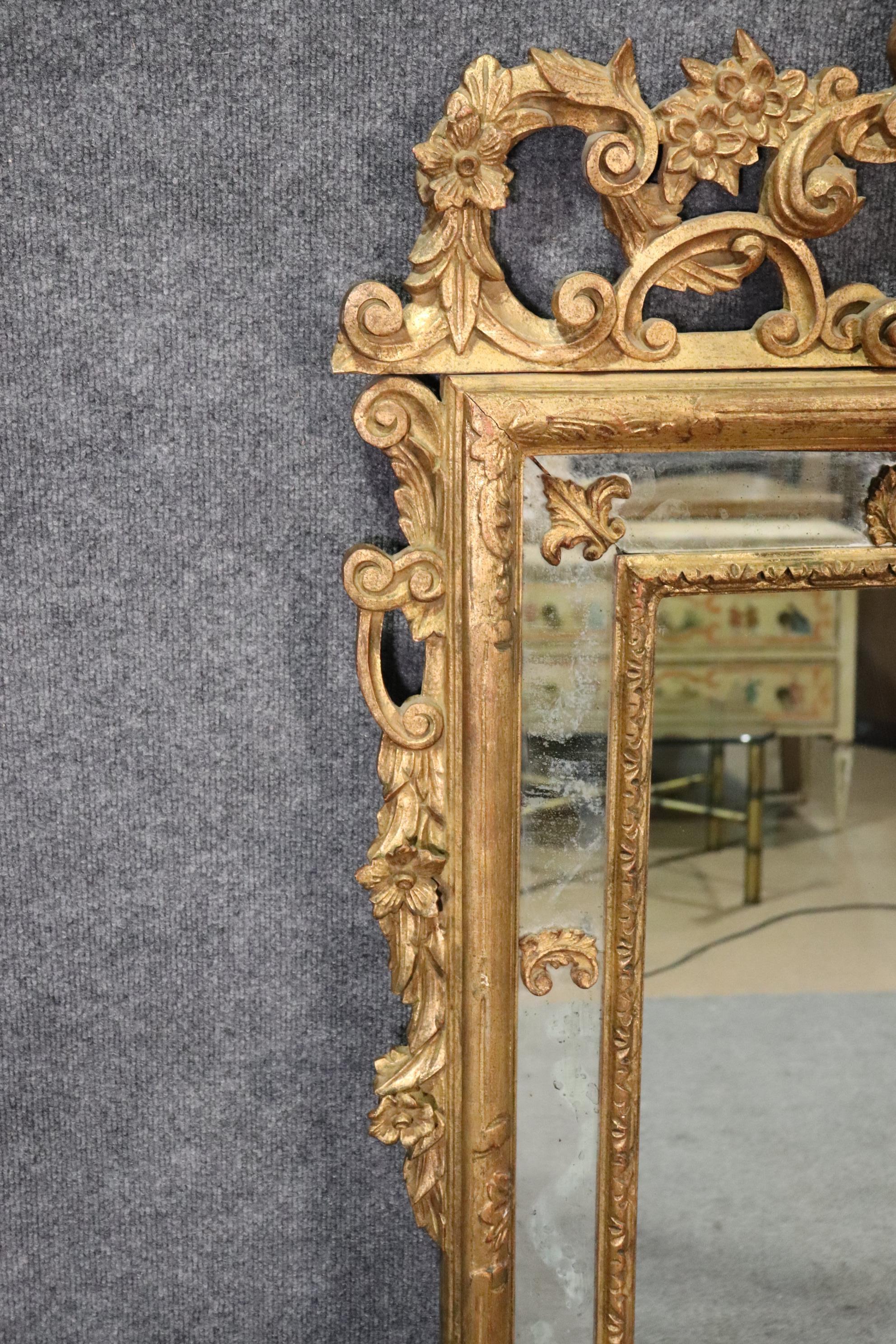 This is a gorgeous 1930s Italian made giltwood mirror. The mirror is incredibly beautiful and while it does have a crack in one of the mirror panels it is stillvery usable the way it is. The mirror measures 60 inches tall x 37 wide x 2.5 inches