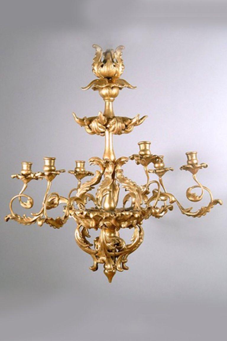 Lustre à six bras en bois doré conservant sa dorure d'origine. La sculpture est superbe et s'inscrit dans le style de la période baroque, avec des éléments de feuillage stylisés dans l'ensemble.