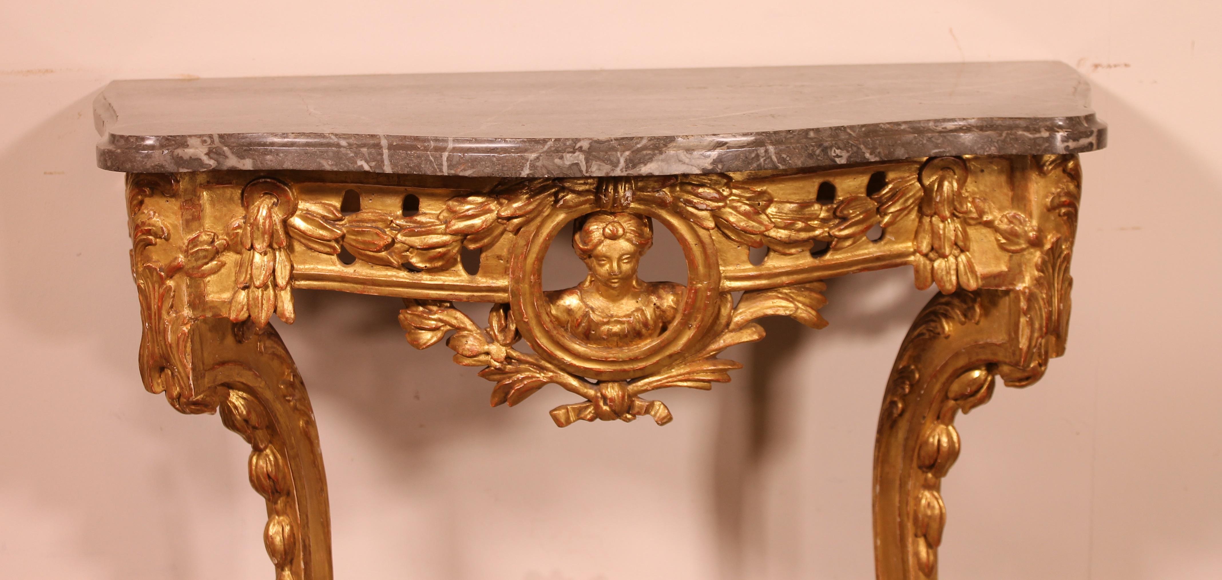 A fine French console in gilded wood from the 18th century transition period (Louis XV-Louis XVI)
A very elegant curved facade that is carved with acanthus leaves and a character representing a woman in its center

The console is topped with a