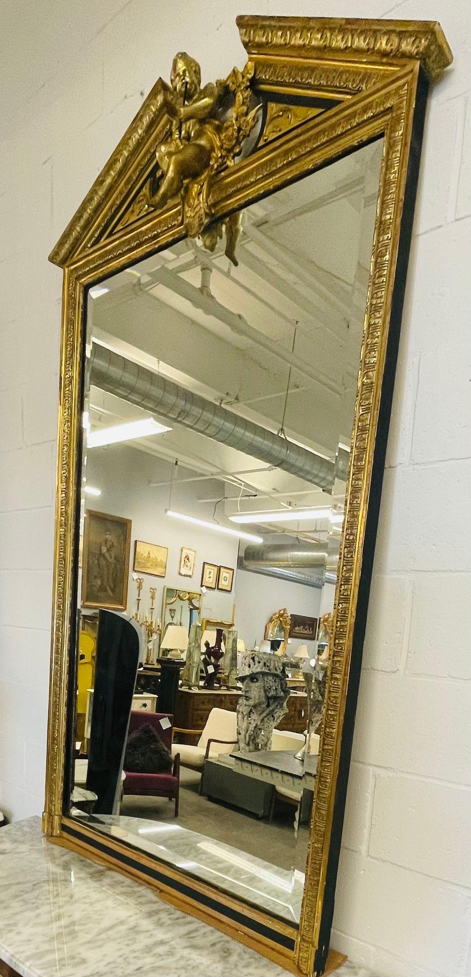 Giltwood Console, Over the Mantle or Floor Mirror, Beveled, 19th/20th Century 
A Stunning carved gilt wood mirror from the late 19th to the early 20th century having a beveled mirror center panel flanked by a gilt gold carved frame terminating in a