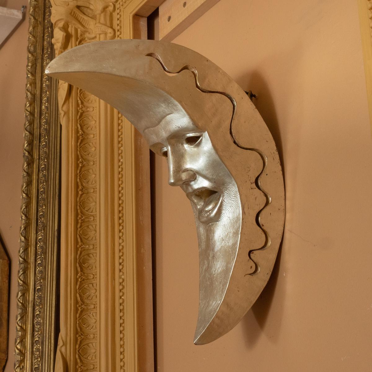 Woodcarving sculpture depicting a personified crescent moon in exquisite detail with white gold finish by master woodworker Carlos Villegas.